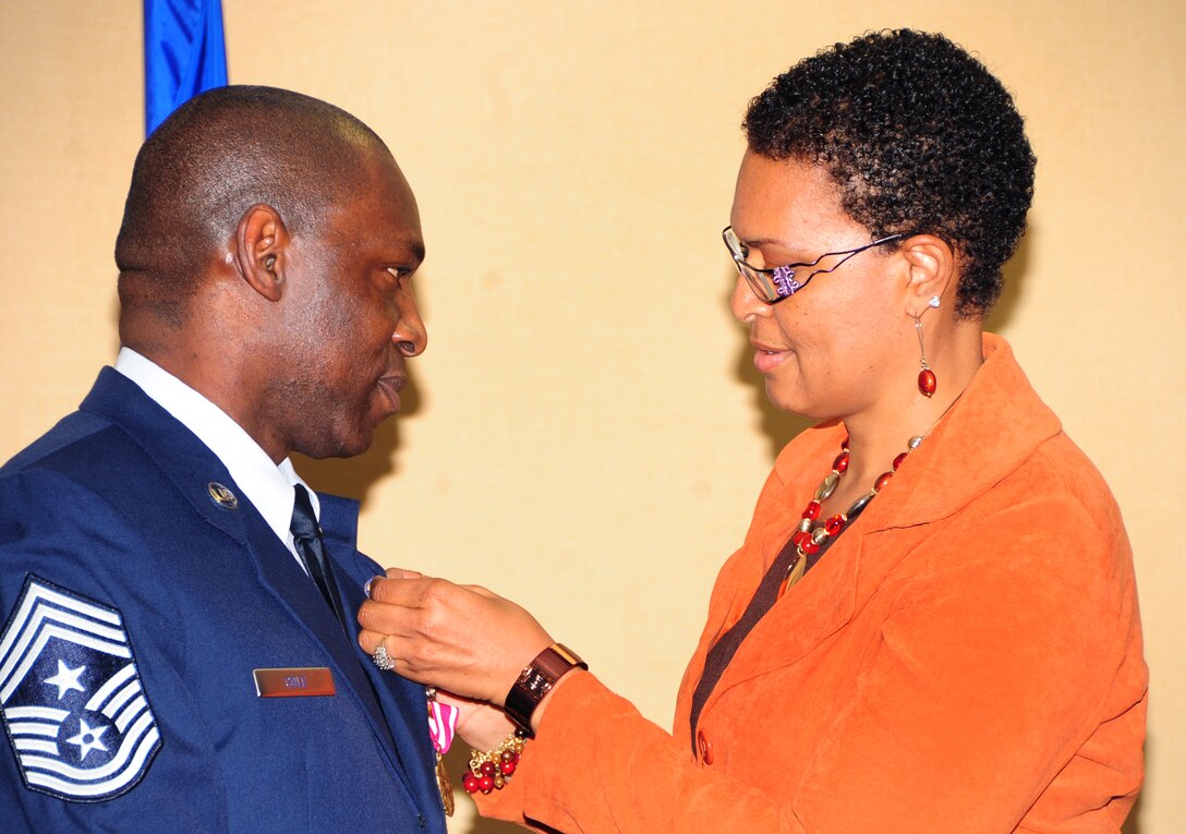 ELLSWORTH AIR FORCE BASE, S.D. -- Chief Master Sgt. Clifton Cole, 28th Bomb Wing command chief, accepts his retirement pin from his wife Paula, Dec. 3.  Airmen, coworkers, family and friends of Chief Clifton Cole gathered at the Dakota’s Club to pay tribute and recognize him for his 30 years of distinguished service. (U.S. Air Force photo/Senior Airman Anthony Sanchelli)
