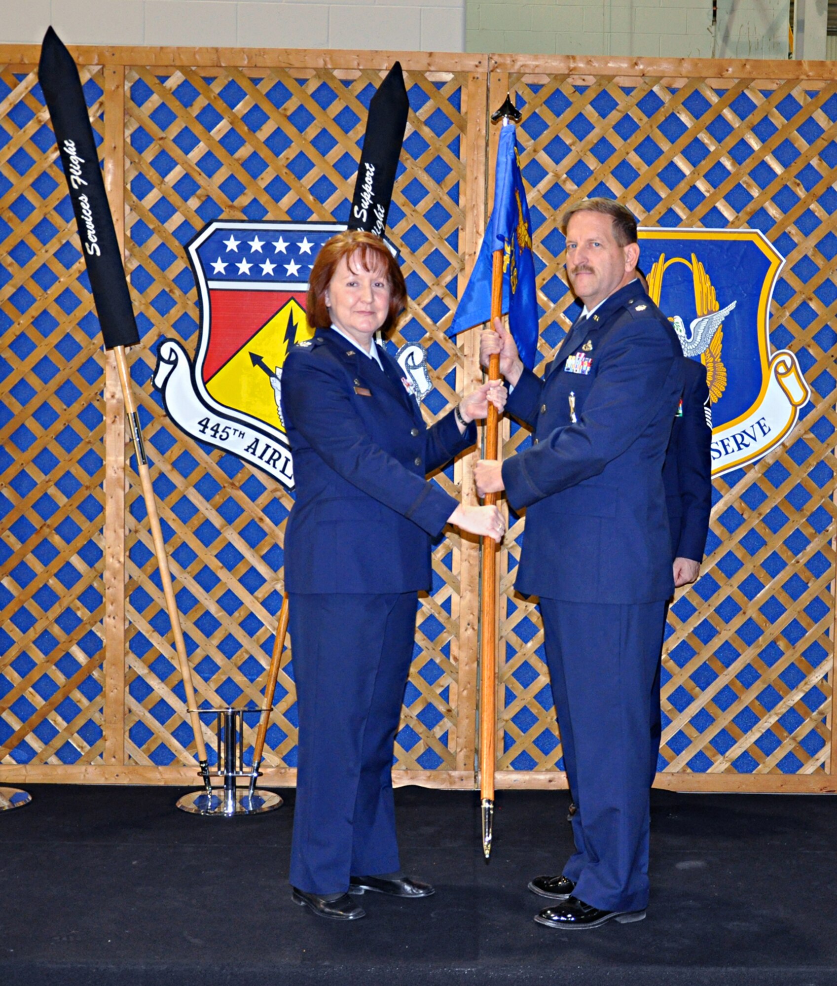 WRIGHT-PATTERSON AIR FORCE BASE, Ohio – Col. Mary Henderhan, 445th Mission Support Group commander, passes the guidon to Lt. Col. Kenneth Herstine, commander for the newly activated 445th Force Support Squadron, during the squadron’s activation ceremony Dec. 4.  The activation combines both the 445th Services and Mission Support Flights, an Air Force-wide initiative to merge both personnel and services functions into one organization. (U.S. Air Force photo/Senior Airman Mikhail Berlin)