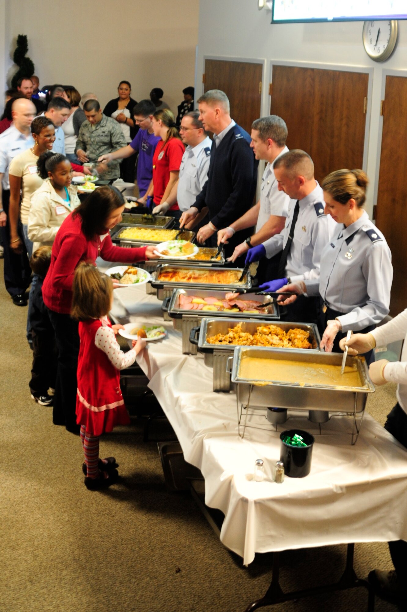 Commanders and leaders serve dinner at the quarterly Deployed Families Dinner Dec. 6 at McChord Field, Joint Base Lewis-McChord, Wash. The night included a meal, door prizes, a live brass band and opportunities for children to get pictures taken with Santa Claus. (U.S. Air Force photo/Airman Leah Young)