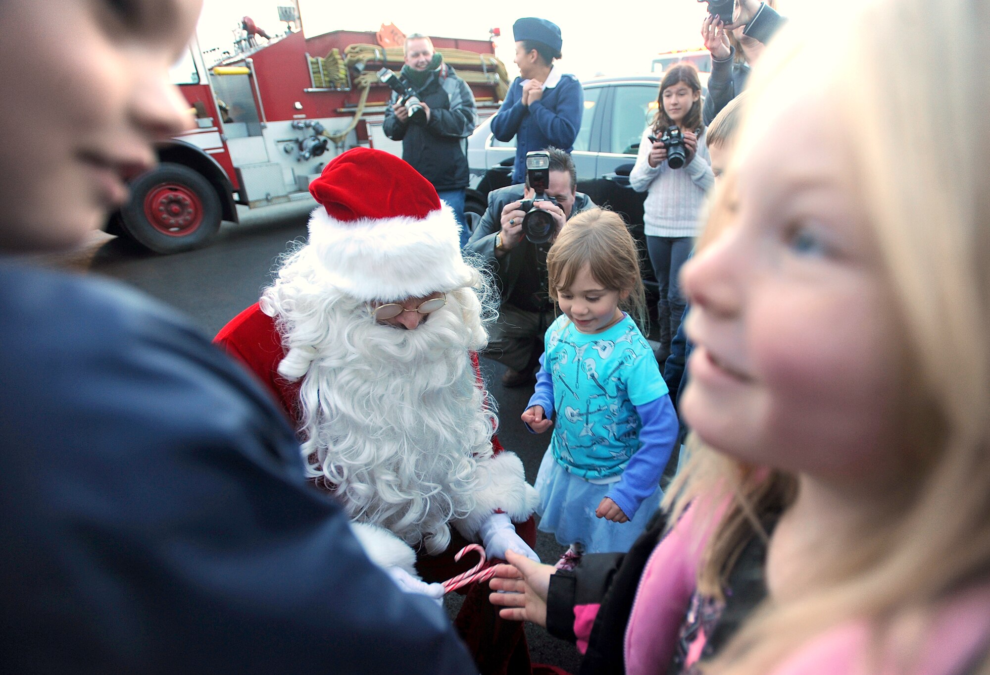Santa Claus hands out candy canes and other treats to excited children at the annual tree-lighting ceremony Dec. 6 at McChord Field, Joint Base Lewis-McChord, Wash. The tree-lighting ceremony was followed by the quarterly Deployed Families Dinner.  (U.S. Army photo/Ingrid Barrentine)