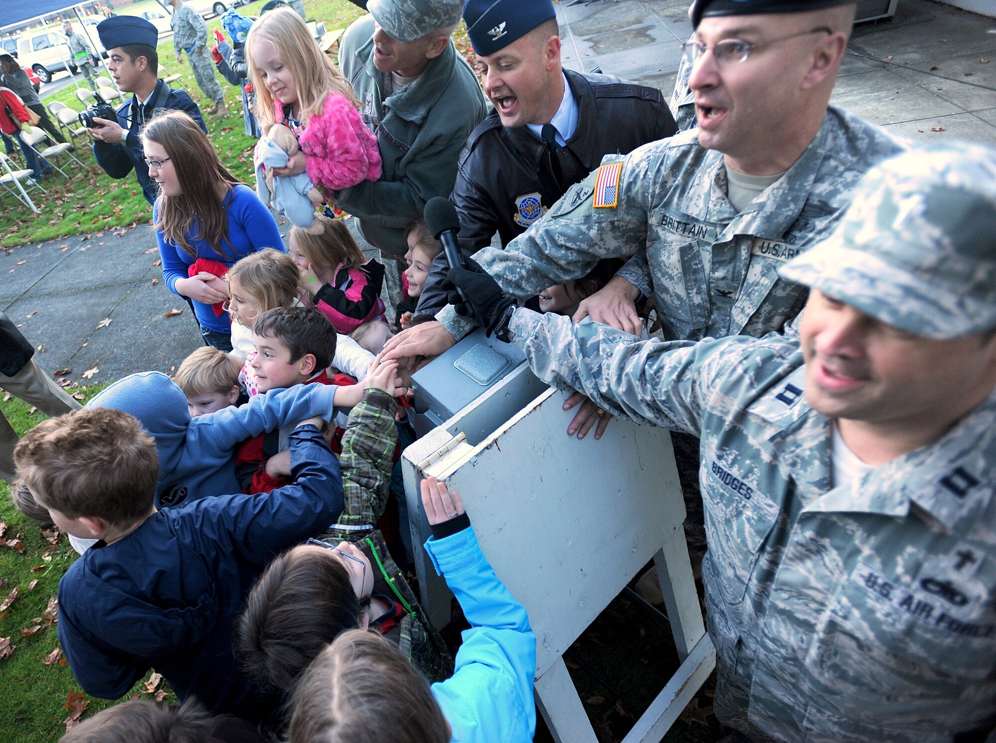 Leadership representing Joint Base Lewis-McChord, Wash., help children pull a power switch to turn on the lights of a decorated holiday tree Dec. 6 at the annual tree-lighting at McChord Field, JBLM. (U.S. Army photo/Ingrid Barrentine)