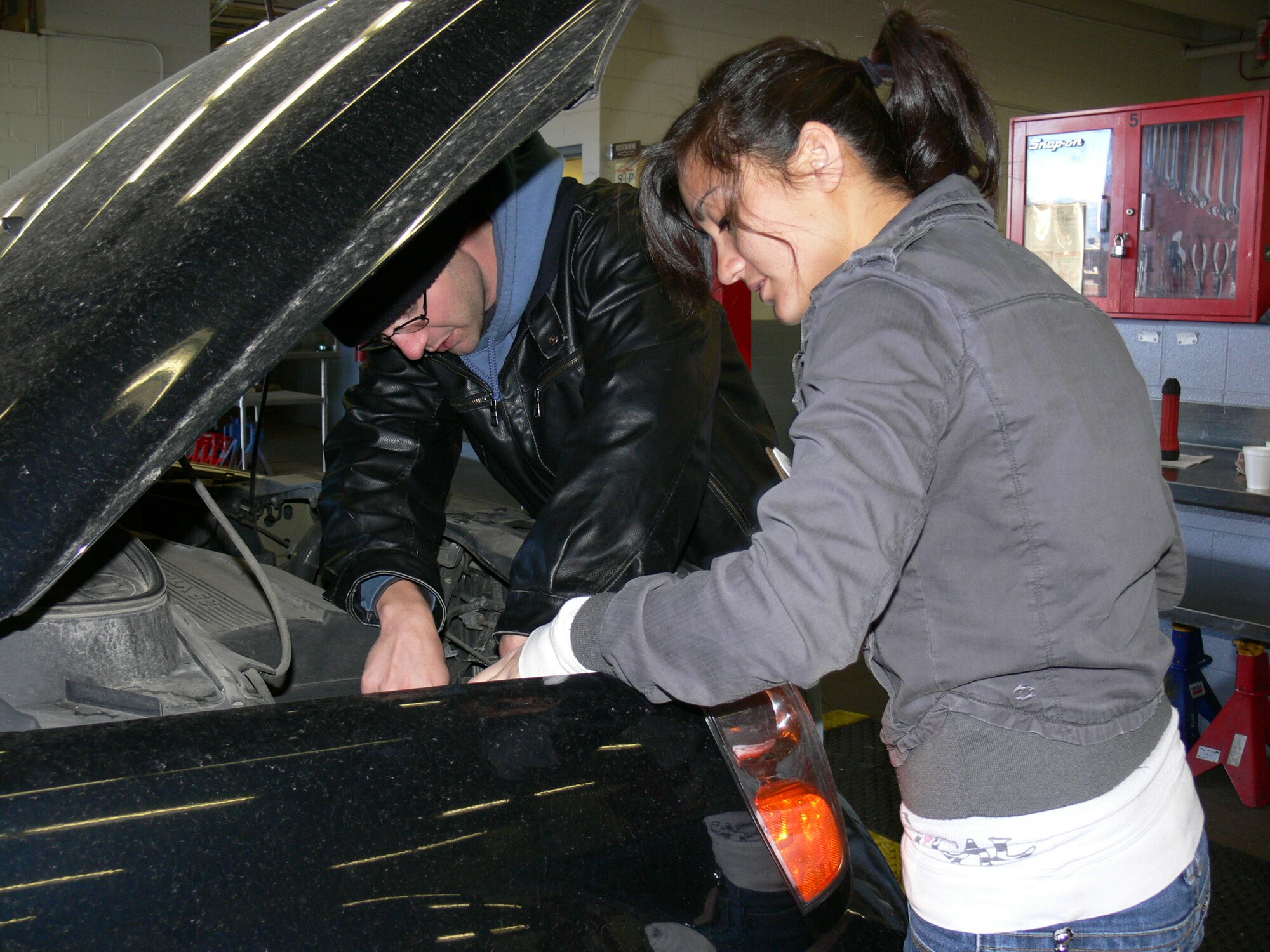 Airman 1st Class Justin Kirby, 21st Military Personnel Section, and Airman 1st Class Lisa Klevenberg, 21st Logistics Readiness Squadron, check the oil, fluids and belts on a vehicle during a free winter vehicle inspection at the 21st Force Support Squadron’s Auto/Hobby Center on Peterson AFB Dec. 2. Auto/Hobby Center mechanics, 15 volunteers and the 21st Space Wing Safety Office teamed to provide the free inspections to raise awareness for the need to keep vehicles winterized. The prognosis for this vehicle: time for an oil change. (U.S. Air Force photo/Monica Mendoza)