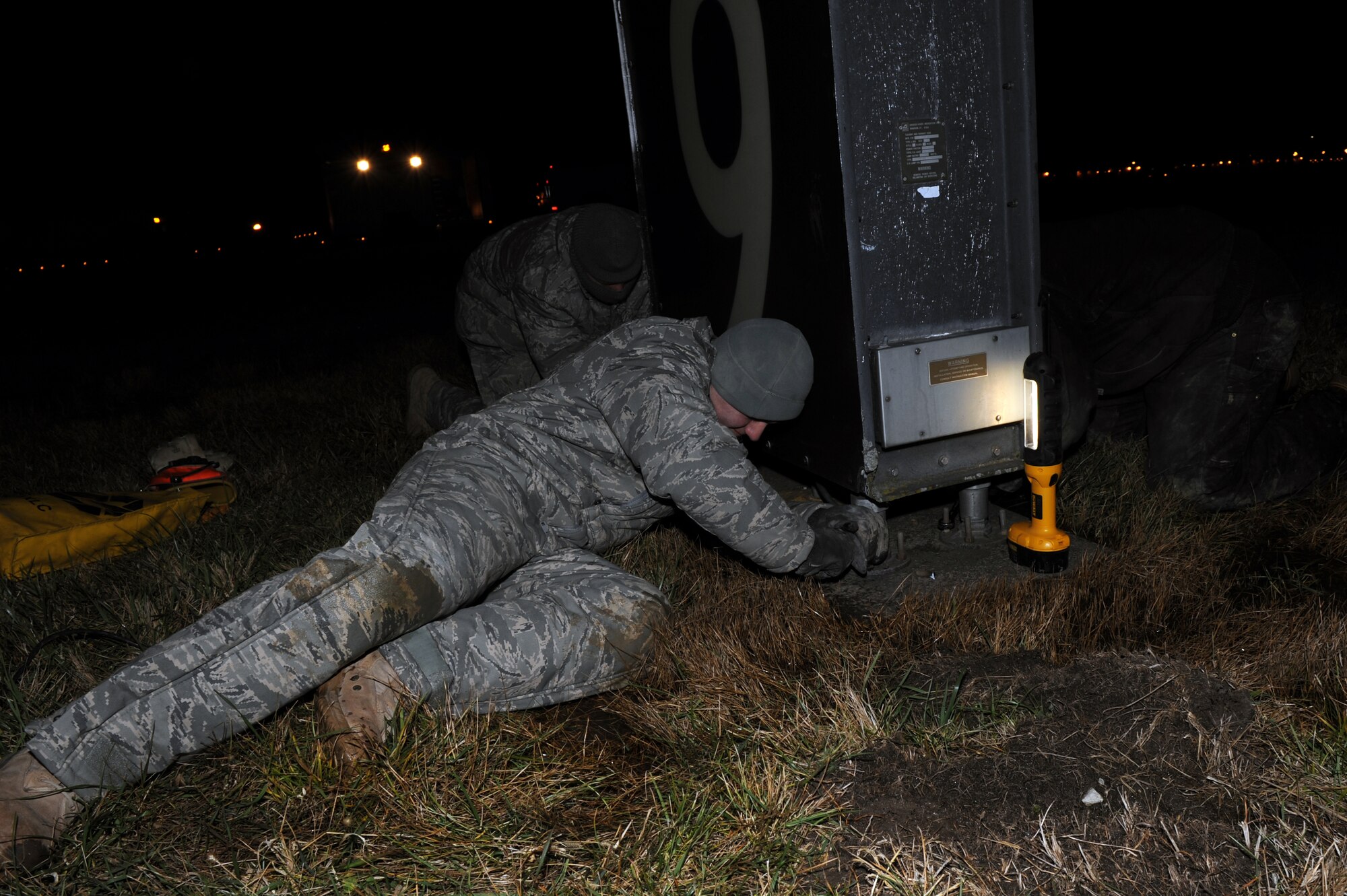 WHITEMAN AIR FORCE BASE, Mo. -- Airman 1st Class Corey Logsdon, 509th Civil Engineer Squadron electrician, prepare to remove an old runway-distance-remaining marker by loosening anchor bolts and upgrade it to a new light-emitting diode fixture. The LED fixtures are designed to cut energy costs by 70 percent. (U.S. Air Force photo by Staff Sgt. Jason Huddleston) (Released)