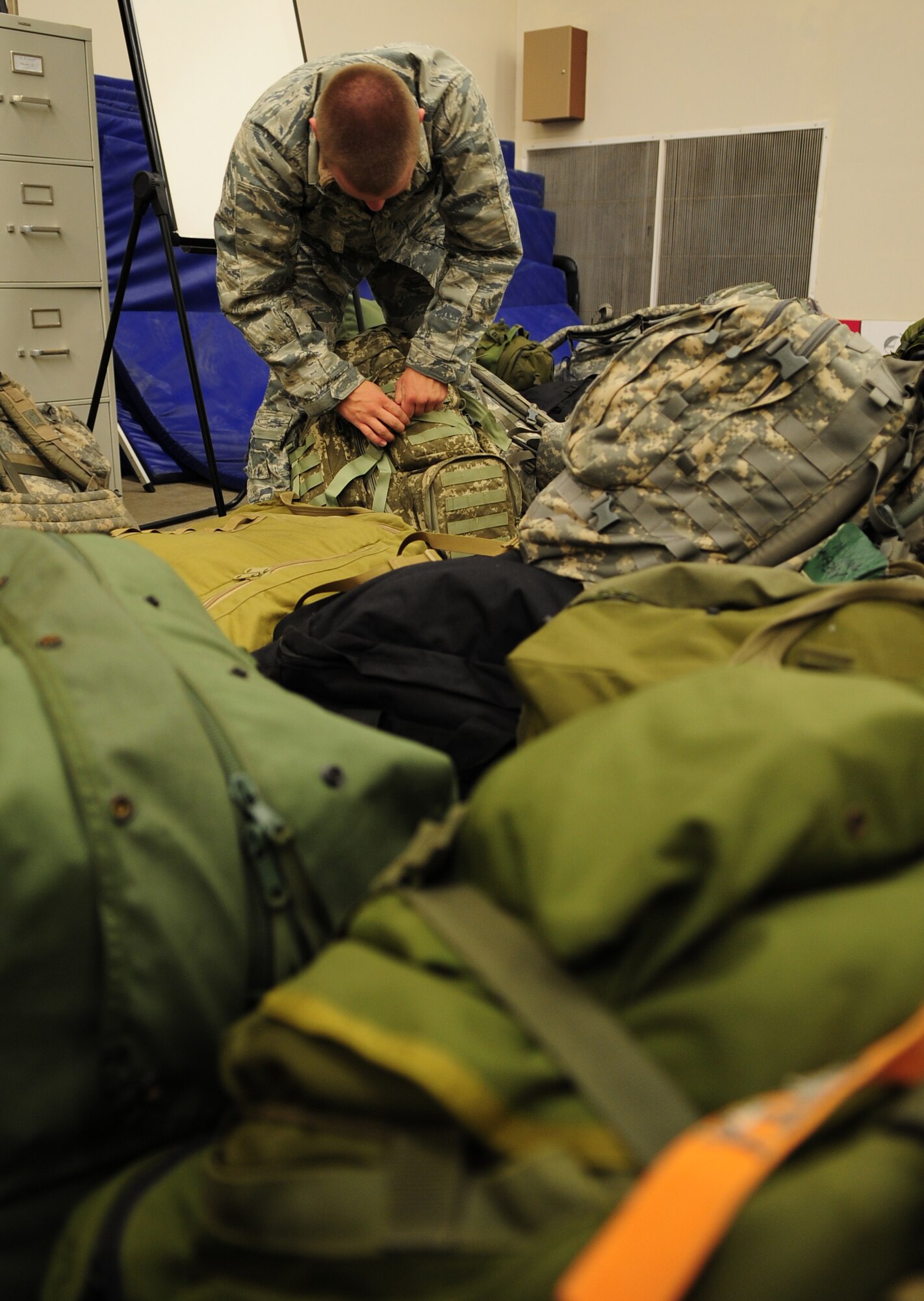 MOODY AIR FORCE BASE, Ga. -- Senior Airman Joel Womack, 822nd Base Defense Squadron fire team member, double checks his equipment before loading it onto a bus. Members from the 820th Base Defense Group were hand-selected by their flight commander to deploy and help train Afghan security forces members. (U.S. Air Force photo/Senior Airman Stephanie Mancha)(RELEASED)