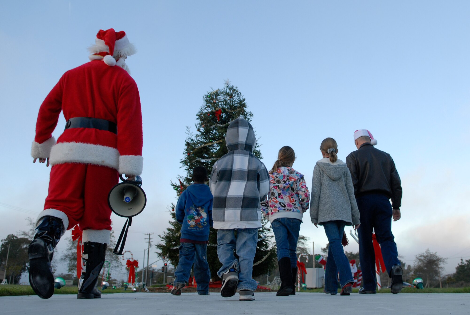 VANDENBERG AIR FORCE BASE, Calif. – Walking up to the tree, Santa Claus, his helpers, and Col. Richard Boltz, 30th Space Wing commander, approach the tree during the annual holiday tree lighting ceremony here Monday, Dec. 6, 2010.  The tree lighting ceremony was held in front of a 30th Mission Support Group facility, Building 11777. (U.S. Air Force photo/Senior Airman Andrew Satran)     