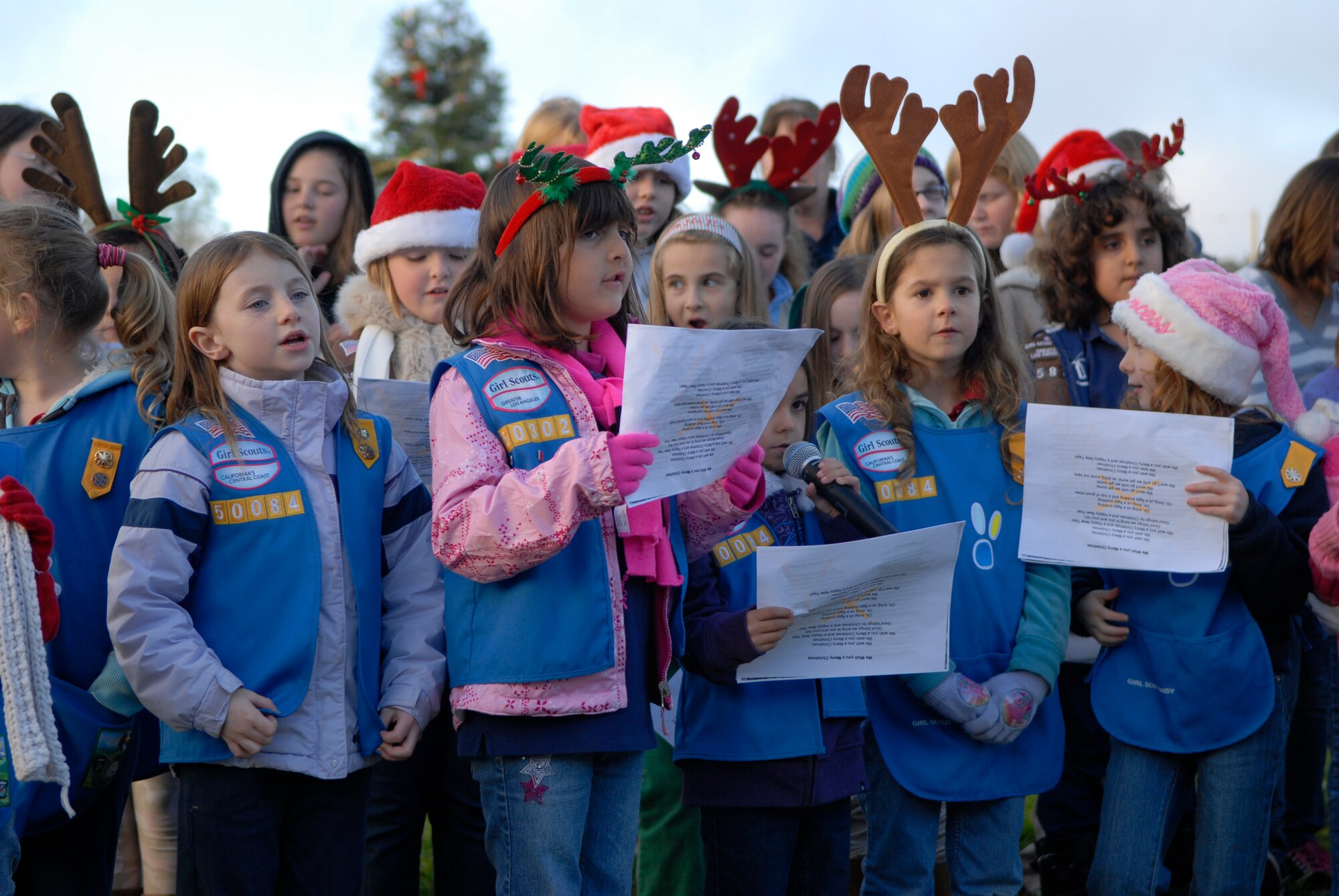 VANDENBERG AIR FORCE BASE, Calif. -- The Vandenberg Girl Scouts sing Christmas carols during the annual holiday tree lighting ceremony here Monday, Dec. 6, 2010.  Wing leadership attended the event along with a special guest, Santa Claus.  (U.S. Air Force photo/Senior Airman Andrew Satran) 
 