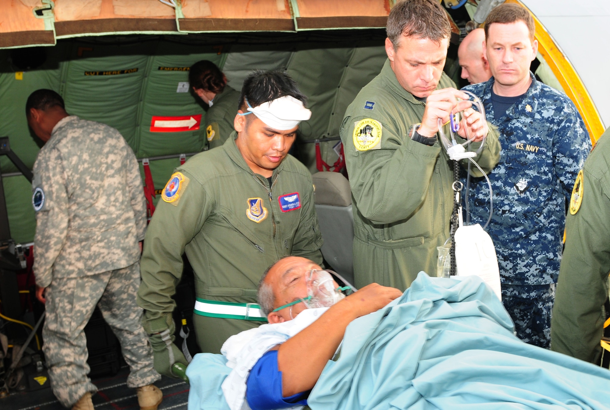 Staff Sgt. Michael Reyes (left), Maj. (Dr.) Aaron Field, and Capt. John Michael Fowler transport a critically ill patient, Nov. 17, 2010, from a KC-135 Stratotanker to Tripler Army Medical Center, Hawaii. This is the first time CCATT East element has transported a critically ill patient during peacetime. (U.S. Air Force photo/Tech. Sgt. Kerry Jackson)
