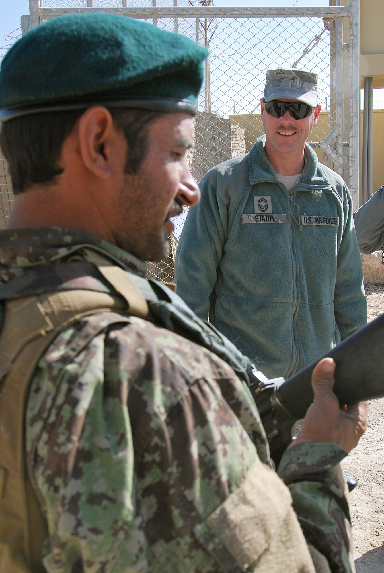 Chief Master Sgt. Dave Staton talks to an Afghan Security Forces airman about his weapon Dec. 1, 2010, at Kandahar Airfield, Afghanistan. Chief Staton is the 738th Air Expeditionary Advisory Group superintendent. As the senior enlisted member, he is also the direct mentor to the Kandahar Air Wing’s enlisted leader, Command Sgt. Maj. Mohammad Hassan. (U.S. Air Force photo/Senior Airman Melissa B. White)