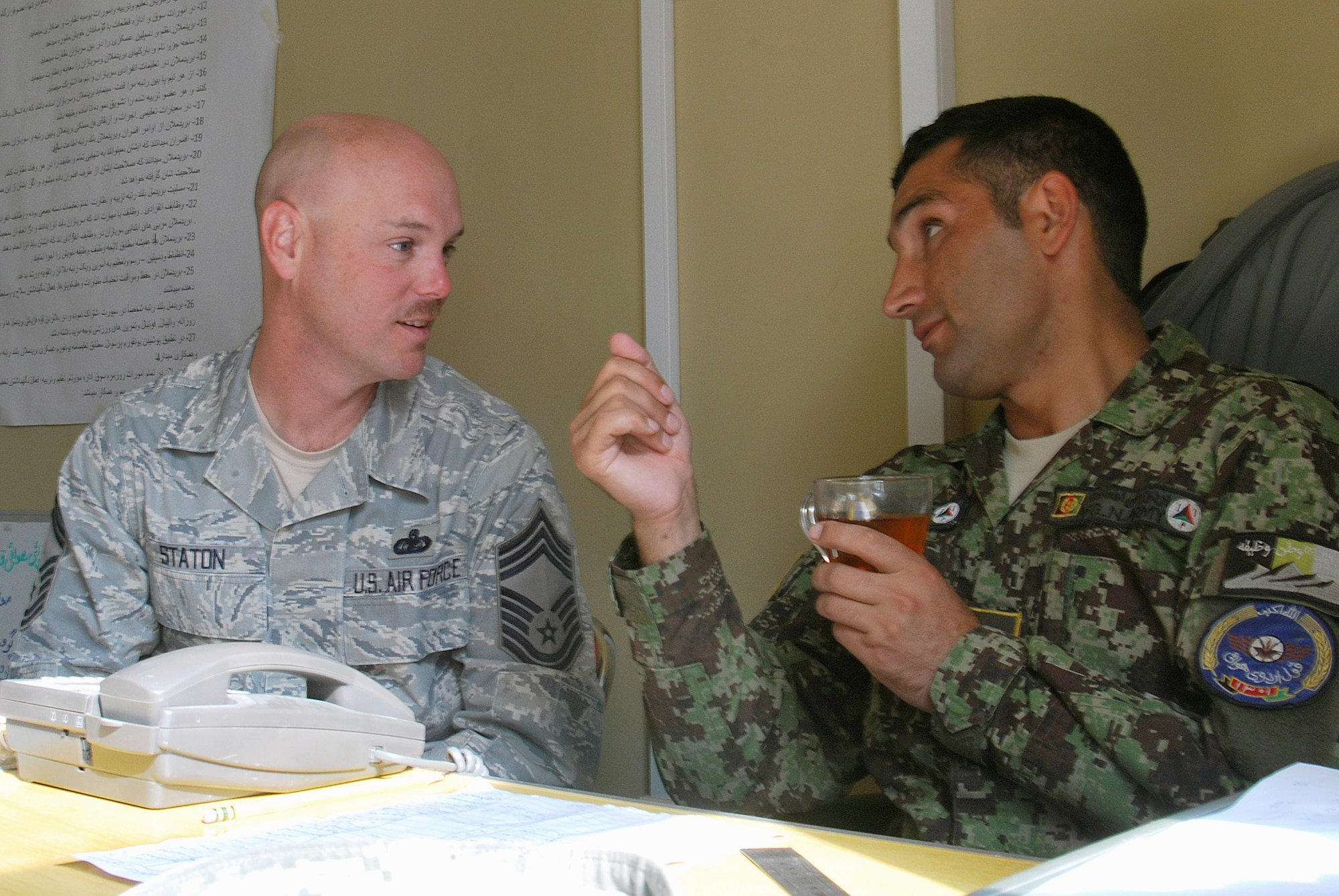 Chief Master Sgt. Dave Staton and Afghan air force Command Sgt. Maj. Mohammad Hassan talk during a meeting Dec. 1, 2010, at Kandahar Airfield, Afghanistan. Chief Staton is the 738th Air Expeditionary Advisory Group superintendent. As the senior enlisted member, he is also the direct mentor to the Kandahar Air Wing’s enlisted leader, Sergeant Major Hassan. (U.S. Air Force photo/Senior Airman Melissa B. White/Released)