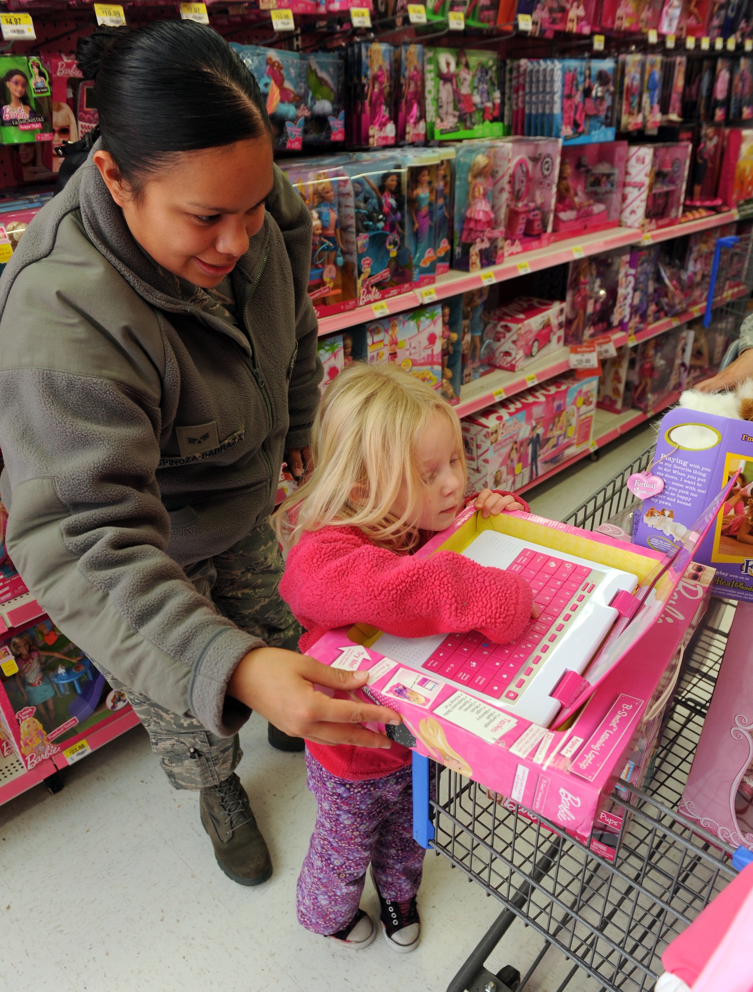 MOUNTAIN HOME, Idaho -- Senior Airman Vanessa Espinoza-Barraza, 366th Logistics Readiness Squadron, helps Kadi pick out a toy during the shop with a cop event in Mountain Home, Dec. 4. This year 120 children were provided with gift cards to go Christmas shopping for themselves and their families. (U.S. Air Force photo by Senior Airman Debbie Lockhart)