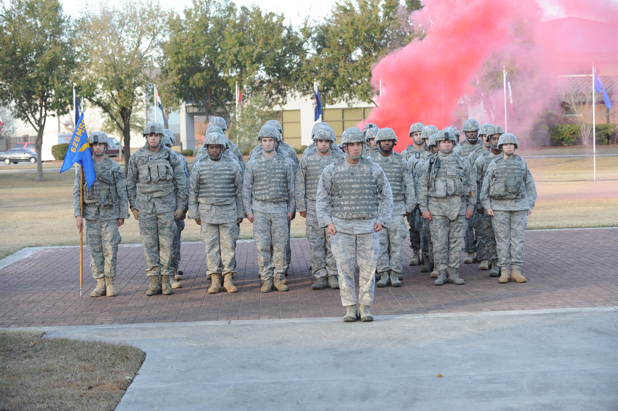 Members from the 628th Security Forces Squadron standby as the folding of the flag commences during a retreat ceremony at Joint Base Charleston, S.C., Dec. 3, 2010. The ceremony is held each day, with formations every Friday. The 628 SFS traditionally performs the ceremony in their unique fashion, donning Kevlar helmets and vests, firing rounds from pre-positioned Humvees and setting off smoke. (U.S. Air Force photo/James M. Bowman)
