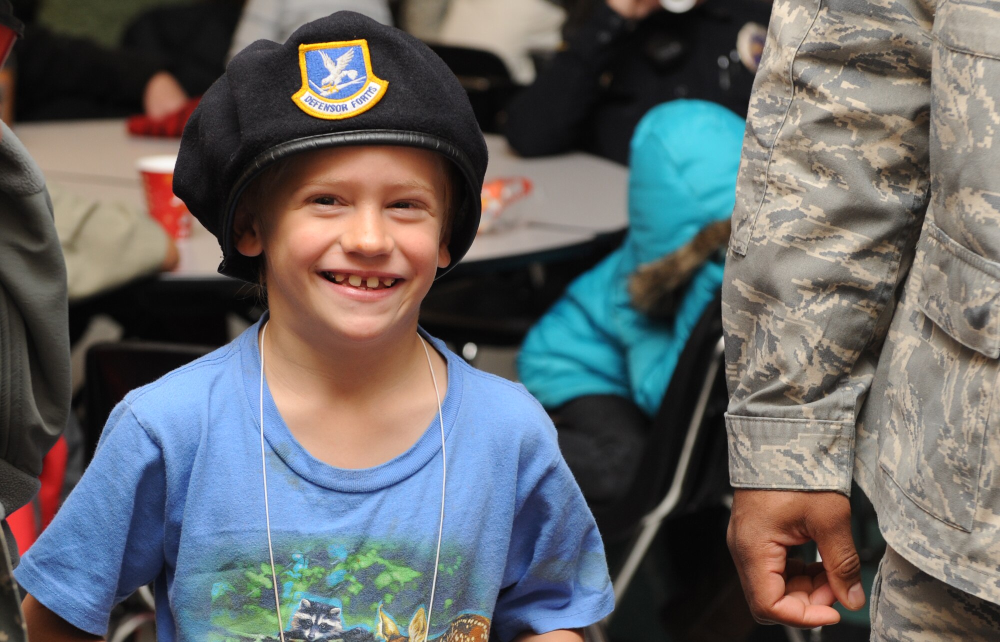 MOUNTAIN HOME, Idaho – David, 7, smiles as he tries on a security forces barrette before going shopping during the shop with a cop event in Mountain Home, Dec. 4. More than 100 children were provided with gift cards to buy themselves and their families Christmas gifts. (U.S. Air Force photo by Senior Airman Debbie Lockhart)