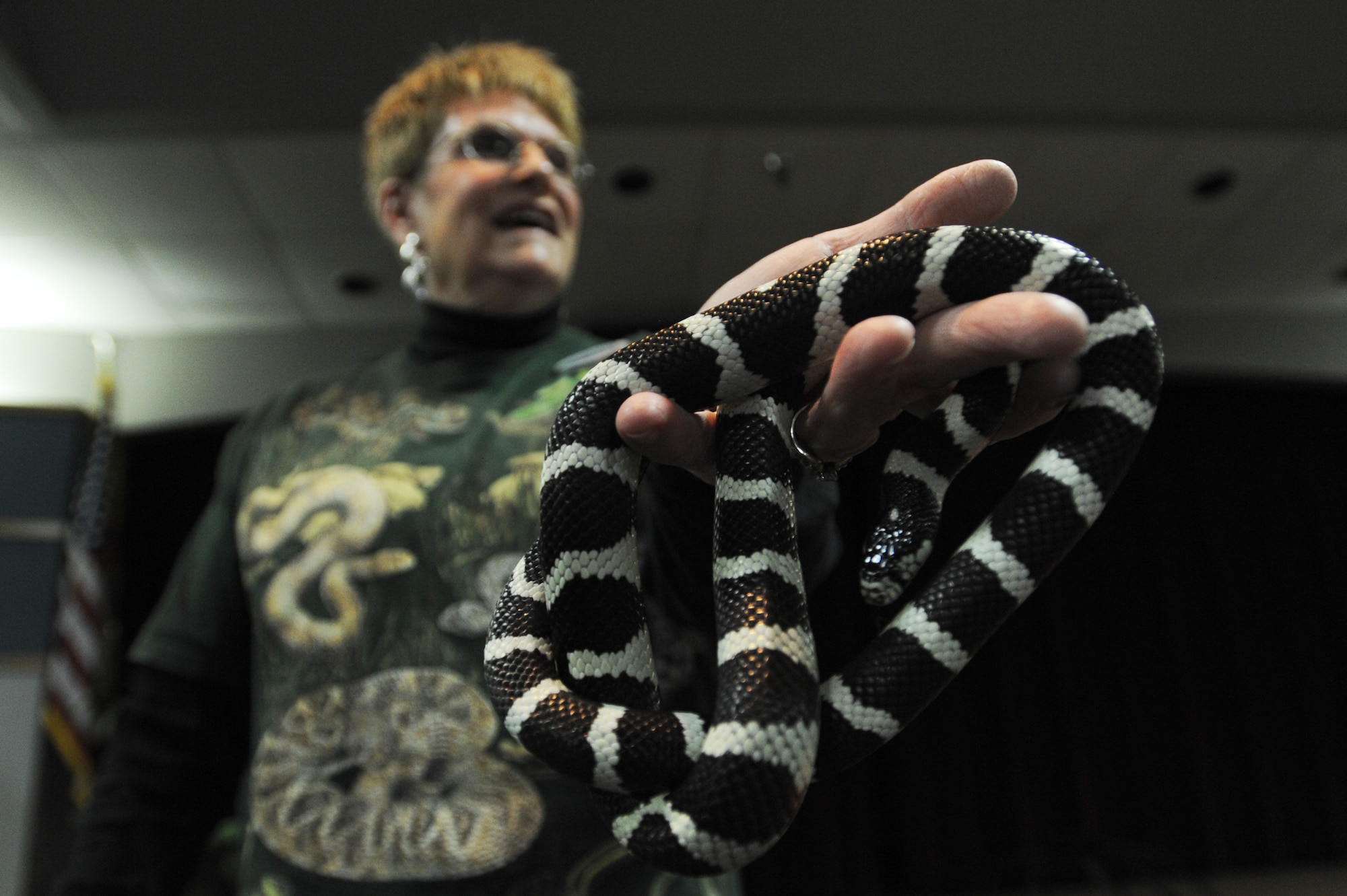 WHITEMAN AIR FORCE BASE, Mo. - Connie Koch, 509th Force Support Squadron community center director, displays a red milk snake during the snake lady and spider-man presentation here, Dec. 4. The presentation was held at the Community Activity Center for an audience of more than 85 Team Whiteman members. (U.S. Air Force photo by senior Airman Carlin Leslie)