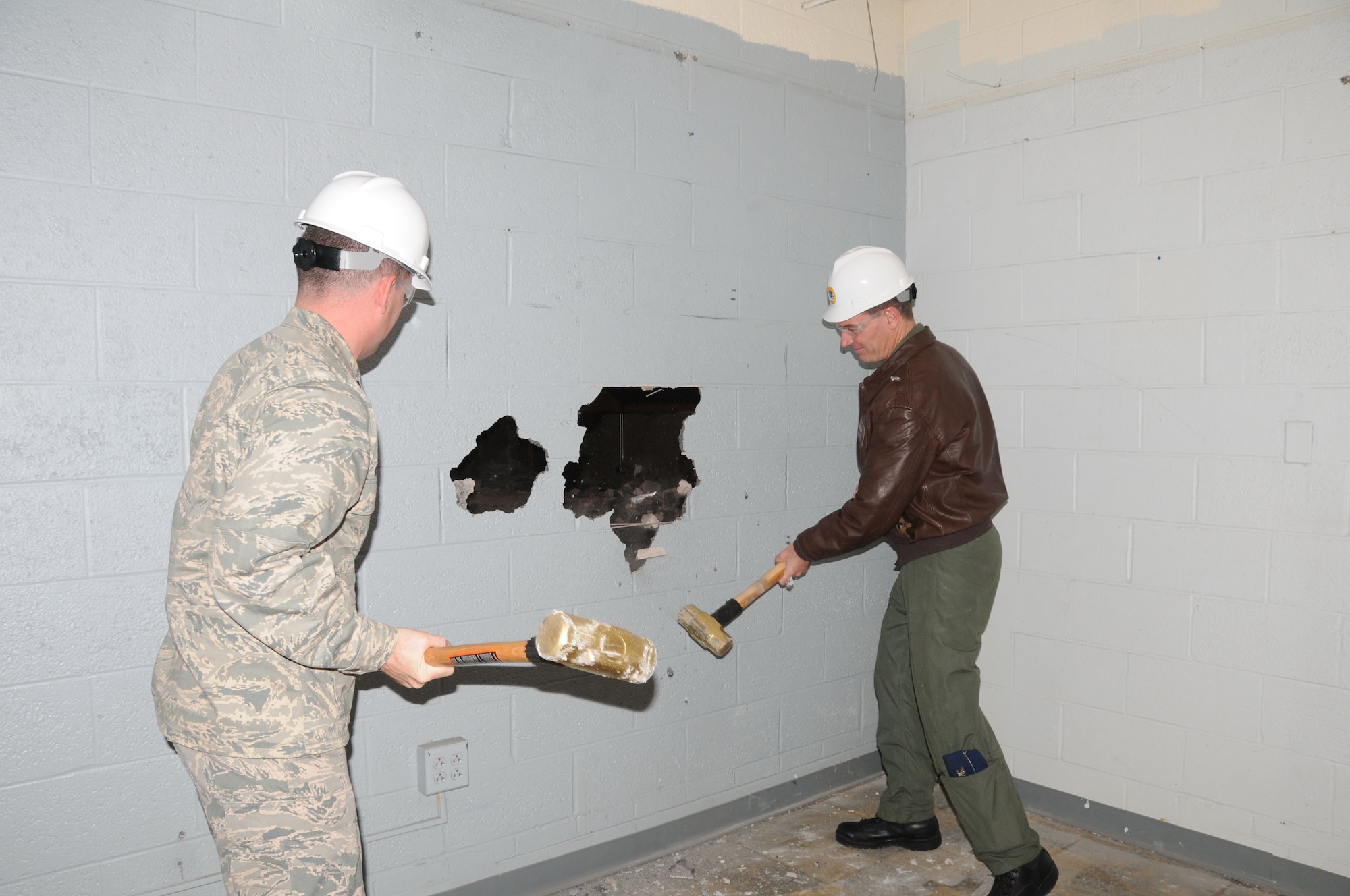 Lt. Col. Jerry McDonald (left), commander of the 103rd Maintenance Group, and Col. Frank Detorie, 103rd Airlift Wing commander, take swings at a wall on the west side of the main hangar at Bradley Air National Guard Base in East Granby, Conn. on Wednesday, Dec. 1, 2010. The “wall breaking” took place following a ceremony marking the start of a renovation project that will help ready the unit for its next mission flying the C-27J Spartan. (U.S. Air Force photo by Tech. Sgt. Erin E. McNamara)