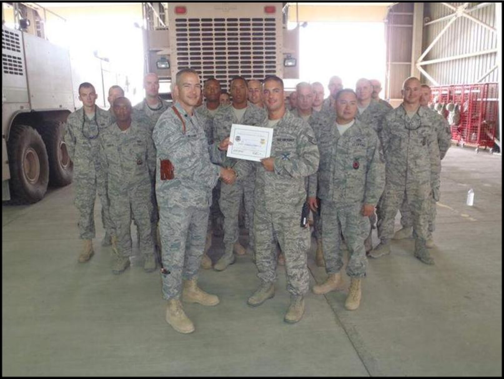 Staff Sgt. Joseph D. Startup (right), a firefighter with the 103rd  Civil Engineer Squadron, receives a handshake and a certificate after being recognized recently as the Tuskegee Airman of the Week while assigned to the 332nd Expeditionary Civil Engineer Squadron, Joint Base Balad, Iraq. (Photo courtesy of Staff Sgt. Joseph D. Startup)