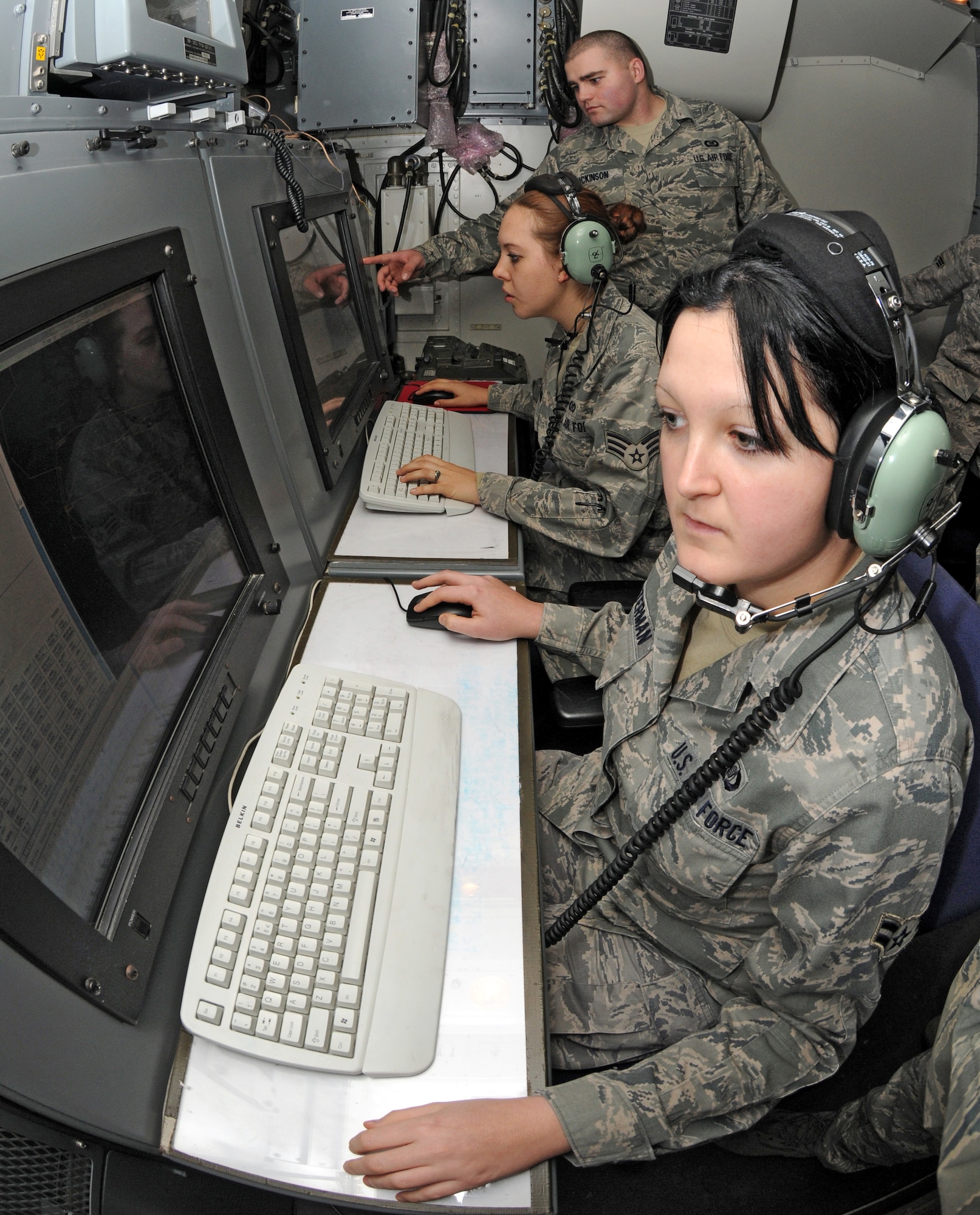 SPANGDAHLEM AIR BASE, Germany – Airman 1st Class Eden Winterman, 606th Air Control Squadron surveillance technician, maintains continuous observation of all the aircraft in the surrounding airspace while Senior Airmen Brett Dickinson and Victoria Sutherland, 606th Air Control Squadron Surveillance technicians, talk about an aircraft on the display monitor Nov. 23. Surveillance technicians communicate with aircraft flying during routine training flights and missions. (U.S. Air Force photo/Airman 1st Class Matthew B. Fredericks)