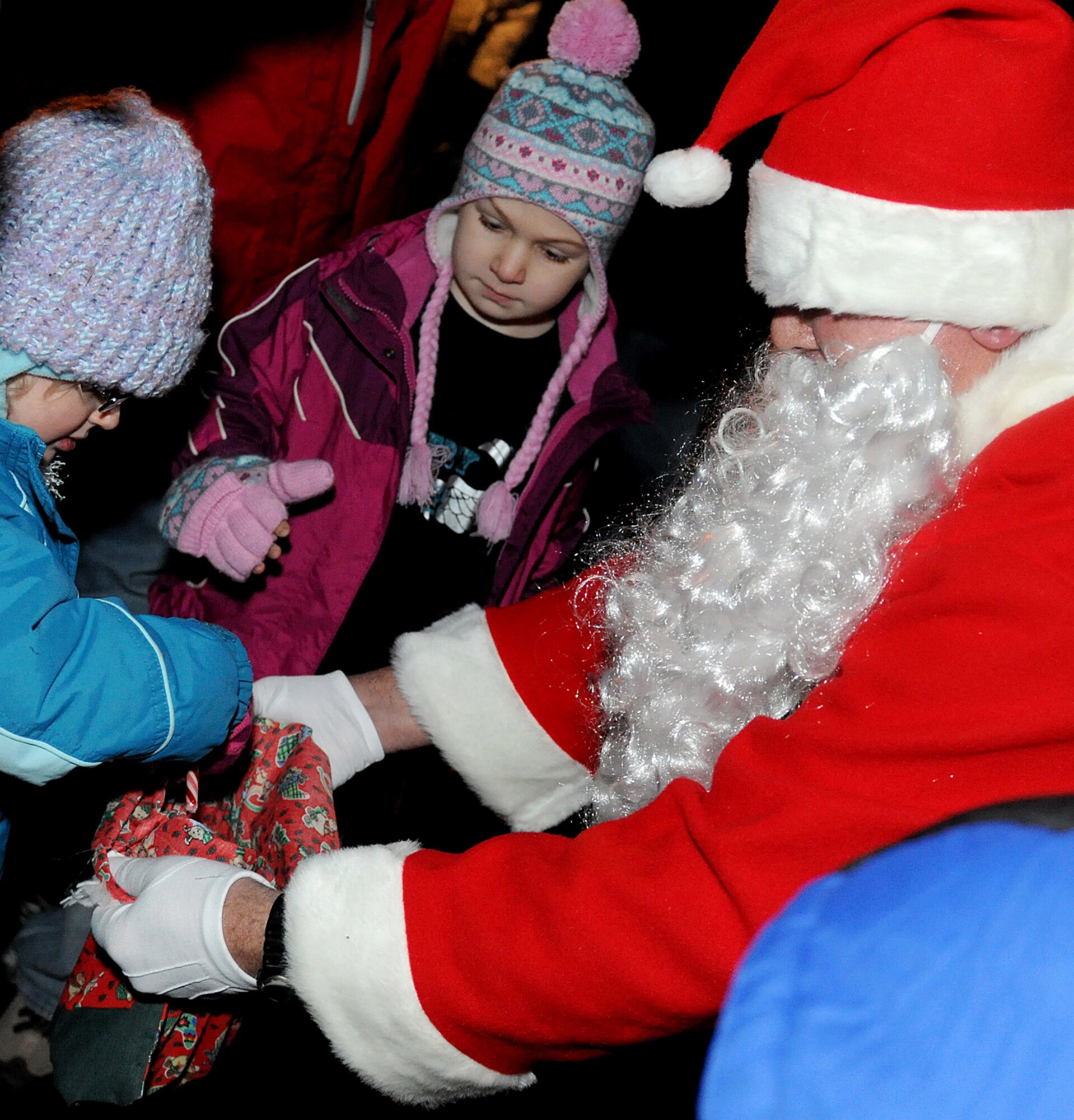 RAF MILDENHALL, England -- A surprise visitor gives out candy at the RAF Mildenhall Christmas Tree lighting Dec. 3, 2010, at the Bob Hope Community Center. Santa arrived in a base fire truck after the tree was lit. (U.S. Air Force photo/Senior Airman Tabitha Lee)