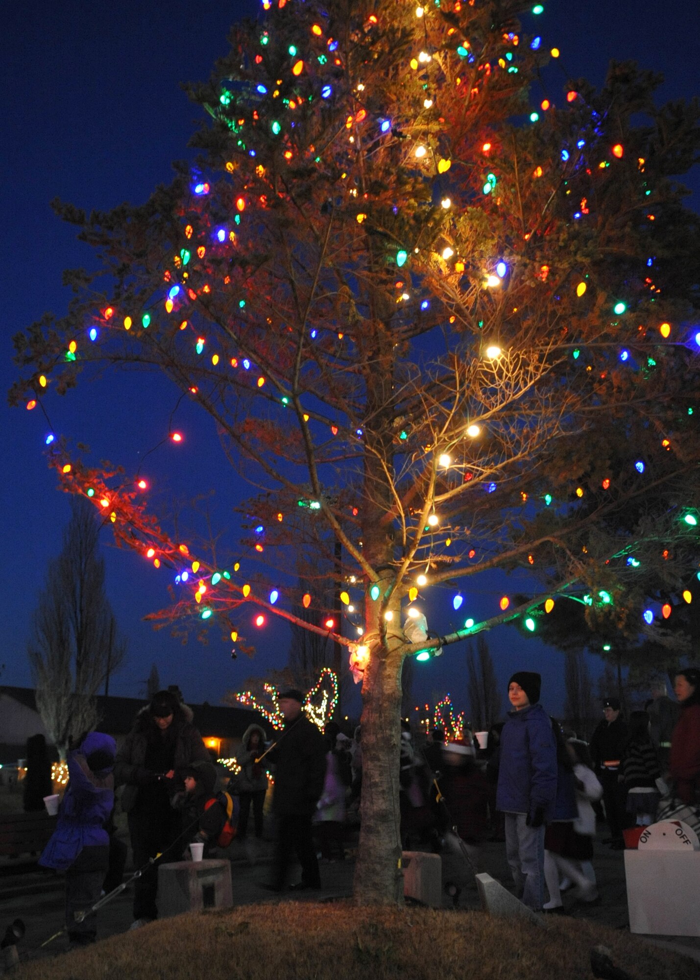 Children gather around the base holiday tree Dec. 6.  The tree lighting ceremony took place in front of the base theater.  The event included a tree lighting cowntdown, music performances by Osan American Elementary School, Santa's arrival, and free hot chocolate. (U.S. Air Force Photo/ Senior Airman Evelyn Chavez)