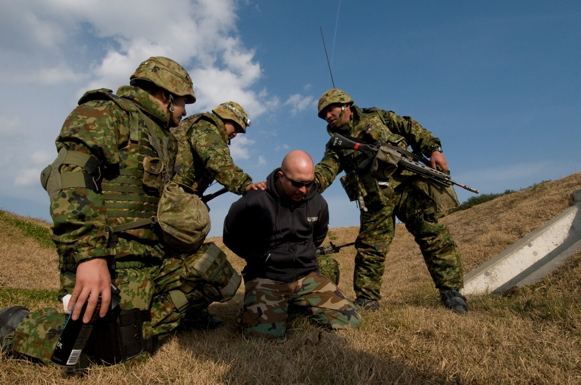 Soldiers from Japan Ground Self Defense Force, 9th Strikethrough Division, 5th Infantry Regiment, Aomori, apprehend Tech. Sgt. George Shepherd, 35th Security Forces Squadron and opposing forces member, Dec. 5, 2010, during a bilateral exercise at Misawa Air Base, Japan.  The JGSDF troops were part of a two-day Guard and Protect Exercise that partnered them with the Japan Air Self-Defense Force 3rd Air Wing and the 35th Security Forces Squadron. (U.S. Air Force photo by Senior Airman Jessica Lockoski)