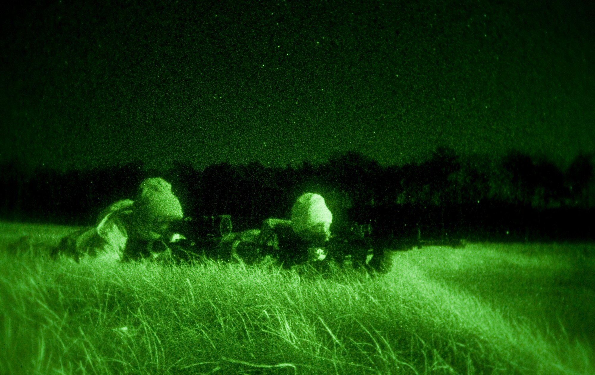 Two 35th Security Forces Squadron members, role-playing as opposing forces, lie prone before ambushing Japan Ground Self Defense Force’s command post, Dec. 2, 2010 during a bilateral guard and protect exercise at Misawa Air Base, Japan.  Opposing forces simulated hostile enemy actions against Japan Ground Self-Defense Force, Japan Air Self Defense Force, and the 35th SFS and tested the combined force’s ability to protect Misawa’s war fighting assets.  (U.S. Air Force photo by Senior Airman Jessica Lockoski)