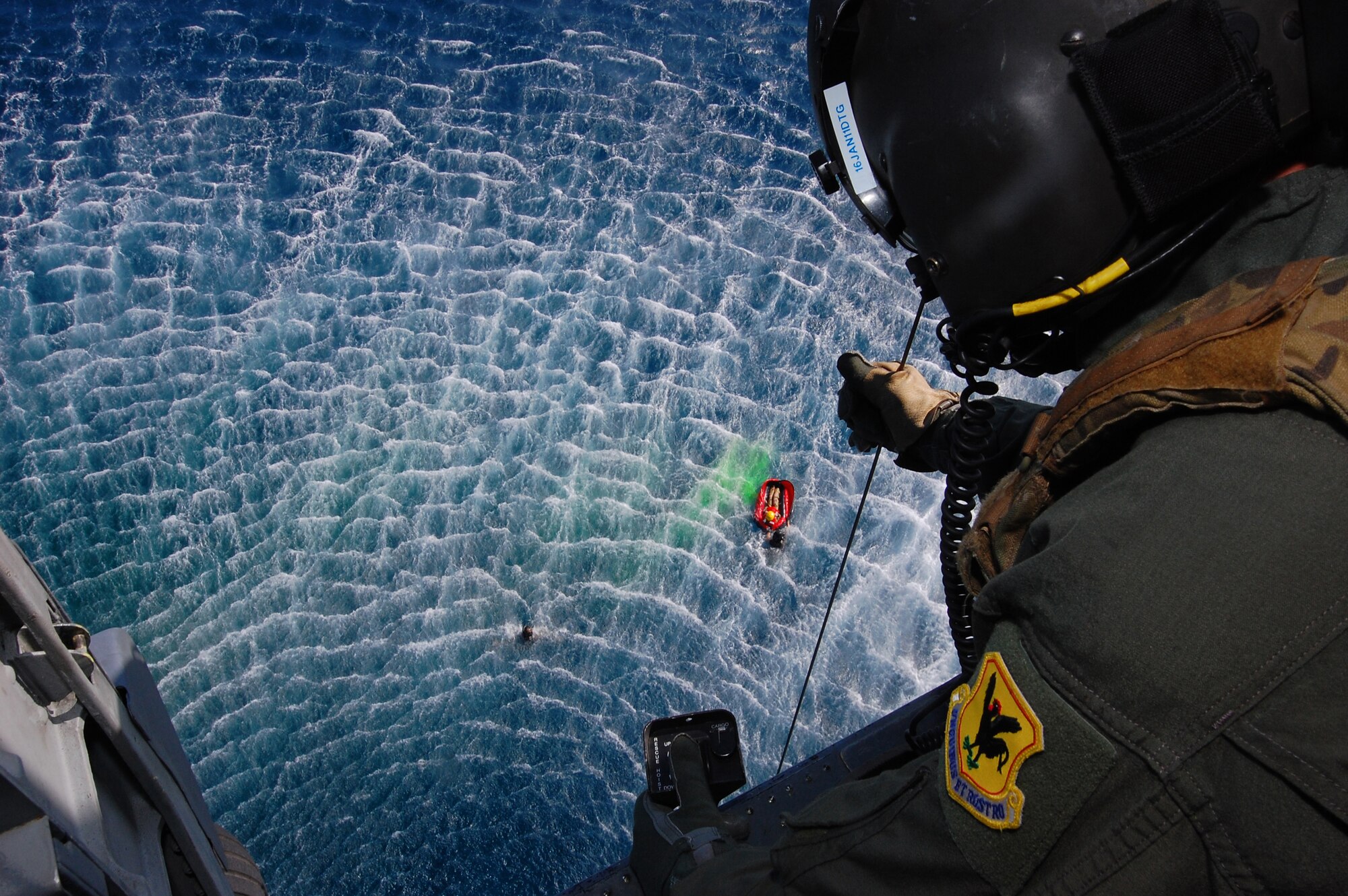 Senior Airman Jeremy Garrett, a flight engineer with the 33rd Rescue Squadron, lowers a stokes down into the waiting hands of the pararescuemen below during the Keen Sword exercise here at Kadena Air Base, Dec. 6. Keen Sword 2011 will include an estimated 10,500 U.S. participants from the Army, Navy, Air Force and Marines. Significant training events during Keen Sword 2011 will include integrated air and missile defense, base security and force protection, search and rescue, close air support, live-fire training, and maritime defense and interdiction. ( U.S. Air Force photo/Staff Sgt. Lakisha A. Croley)