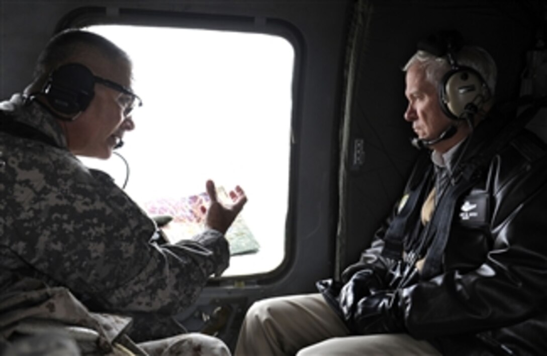 Secretary of Defense Robert M. Gates listens to the Commanding General of the 101st Airborne Maj. Gen. Campbell while in flight to Forward Operating Base Joyce, Afghanistan, on Dec. 7, 2010.  Gates is in Afghanistan receiving operational updates and thanking the troops for their service.  