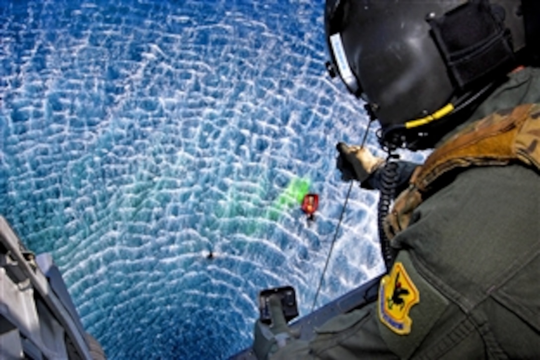 U.S. Air Force Senior Airman Jeremy Garett lowers a stokes down into the waiting hands of pararescuemen during Keen Sword, an exercise on Kadena Air Base, Okinawa, Dec. 6, 2010. Garett, a flight engineer, is assigned to the 33rd Rescue Squadron. The exercise will include about 10,500 U.S. participants from the Army, Navy, Air Force and Marines.