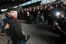 FARMINGDALE, N.Y. -- William Halleran, a Pearl Harbor survivor is recognized by the crowd inside the American Airpower Museum, during the Dropping of the Roses / Pearl Harbor Memorial Ceremony, here, Dec. 7. Halleran is 92 years old and has been making annual appearances at this ceremony for the last decade, this year he was one of four survivors to attend the ceremony. This is the 20th year of a tradition started by the late Joseph Stanley Hydrusko to honor those he served with at Pearl Harbor, Hawaii. Each year roses are dropped over the Statue of Liberty marking the time of the attack. In the attack, 21 ships were sunk or damaged, 188 aircraft were destroyed, and 2,335 service members were killed. America answered with an island-hopping campaign culminating with the iconic Marine Corps flag raising on Iwo Jima more than three years later. (Official Marine Corps photo by Sgt. Randall A. Clinton / RELEASED)