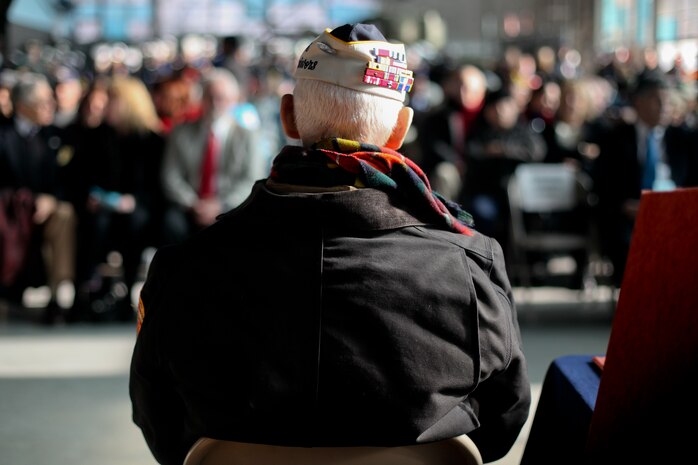 FARMINGDALE, N.Y. -- William Halleran, a Pearl Harbor survivor is recognized by the crowd inside the American Airpower Museum, during the Dropping of the Roses / Pearl Harbor Memorial Ceremony, here, Dec. 7. Halleran is 92 years old and has been making annual appearances at this ceremony for the last decade, this year he was one of four survivors to attend the ceremony. This is the 20th year of a tradition started by the late Joseph Stanley Hydrusko to honor those he served with at Pearl Harbor, Hawaii. Each year roses are dropped over the Statue of Liberty marking the time of the attack. In the attack, 21 ships were sunk or damaged, 188 aircraft were destroyed, and 2,335 service members were killed. America answered with an island-hopping campaign culminating with the iconic Marine Corps flag raising on Iwo Jima more than three years later. (Official Marine Corps photo by Sgt. Randall A. Clinton / RELEASED)