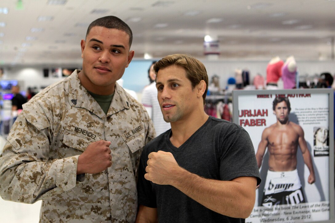 Ultimate Fighting Championship superstar, Urijah Faber gets into a modified fighting stance with Sgt. Bryan S. Menendez, a motor transport operator with the Marine Wing Support Squadron 372 Marine Wing Support Group 37, during a book signing event at the MCX on Camp Pendleton, June 6. The California native and former featherweight champion visited Pendleton to promote the recent release of his book, “The Laws of the Ring.”