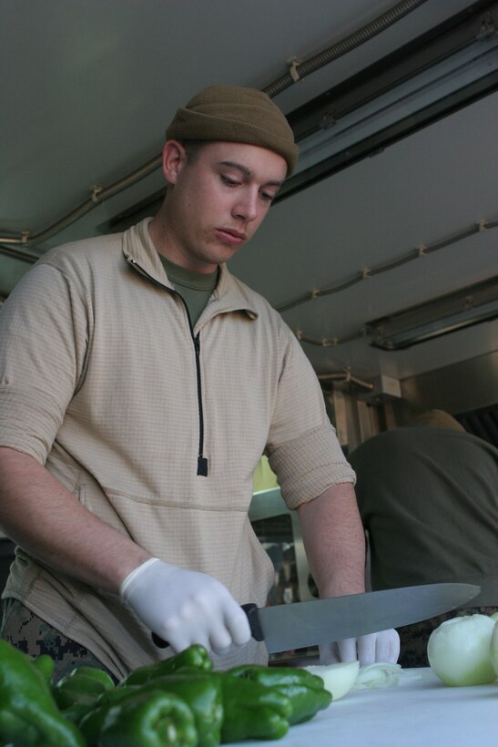 Sgt. Richard J. Martin, Marine Wing Support Squadron 171 food service specialist and chief cook, slices and dices green peppers and onions in the field expedient kitchen set up at Penny lake here Dec. 8 in preparation for the W.P.T. Hill Memorial Award competition.