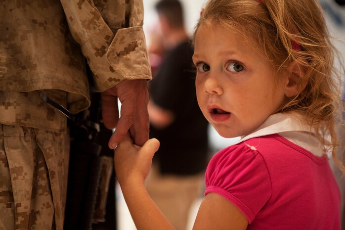 5-year-old Caroline Law grips the hand of her father, Chief Warrant Officer 2 James Law, battalion gunner, 3rd Battalion, 3rd Marine Regiment, following his return to Marine Corps Base Hawaii from a seven-month deployment to Afghanistan, Dec. 7, 2010. After replacing 1st Battalion, 3rd Marine Regiment, in Helmand province’s Nawa district last May, 3/3 supported Regimental Combat Teams 1 and 7, as part of counterinsurgency operations during Operation Enduring Freedom. The battalion’s operations varied from securing elections and ensuring school openings, to more traditional combat operations such as security patrols and clearing danger areas, said Maj. Jay Garcia, executive officer, 3/3, of Honolulu. The return of “America’s Battalion” brought 925 Marines back to Hawaii.