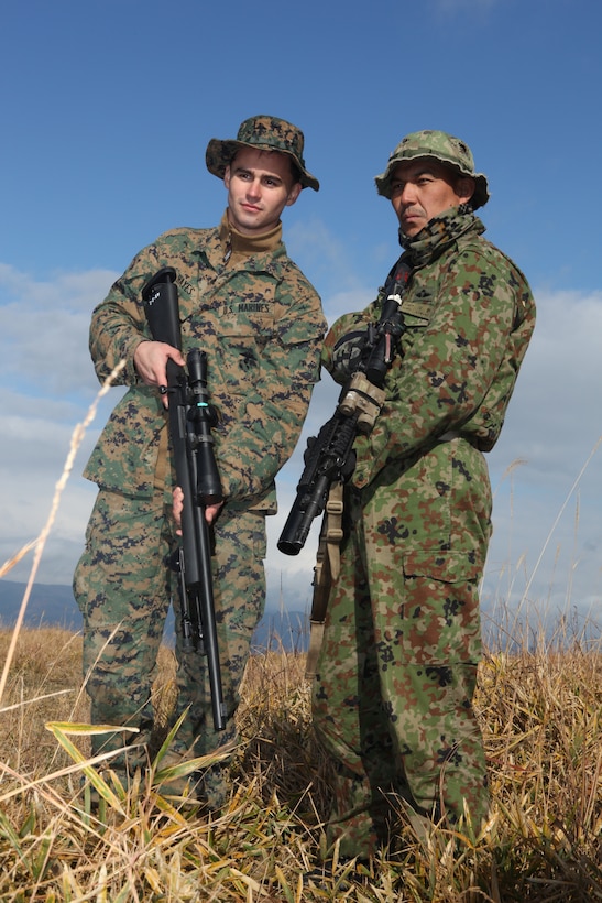 U.S. Marine Cpl. Justin Hayes, 21, from Pittsburg, Penn., an assistant team leader, Scout Sniper Platoon, Weapons Company, Battalion Landing Team 1st Battalion, 7th Marines, 31st Marine Expeditionary Unit, poses for a photo after a sniper training evolution with Japanese Sgt. 1st Class Yogi Kawano, sniper, 2nd Co., 43rd Infantry Regiment, Japanese Ground Self Defense Force, during exercise Forest Light, Dec, 8.  Forest Light is an annual bilateral exercise designed to enhance interoperability and maintain readiness of both U.S. and Japanese ground forces.