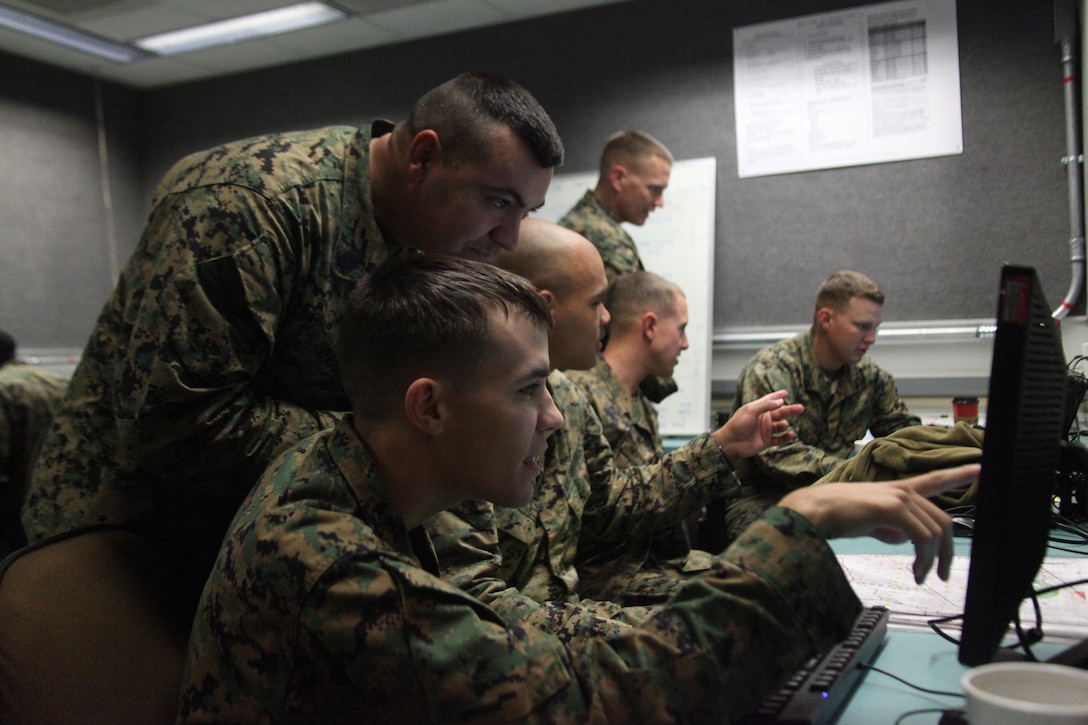 Corporal Blake Meyer a company clerk with Company B, Headquarters Battalion and First Sgt. Nelson Hidalgo Company B first sergeant with Headquarters Battalion, discuss Meyer’s last shot during a call for fire simulation, Dec. 8, 2010, at the Combined Arms Staff Trainer facility at Camp Pendleton, Calif.