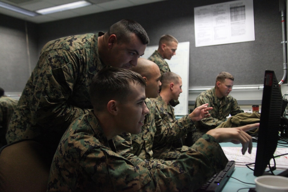 Corporal Blake Meyer a company clerk with Company B, Headquarters Battalion and First Sgt. Nelson Hidalgo Company B first sergeant with Headquarters Battalion, discuss Meyer’s last shot during a call for fire simulation, Dec. 8, 2010, at the Combined Arms Staff Trainer facility at Camp Pendleton, Calif.
