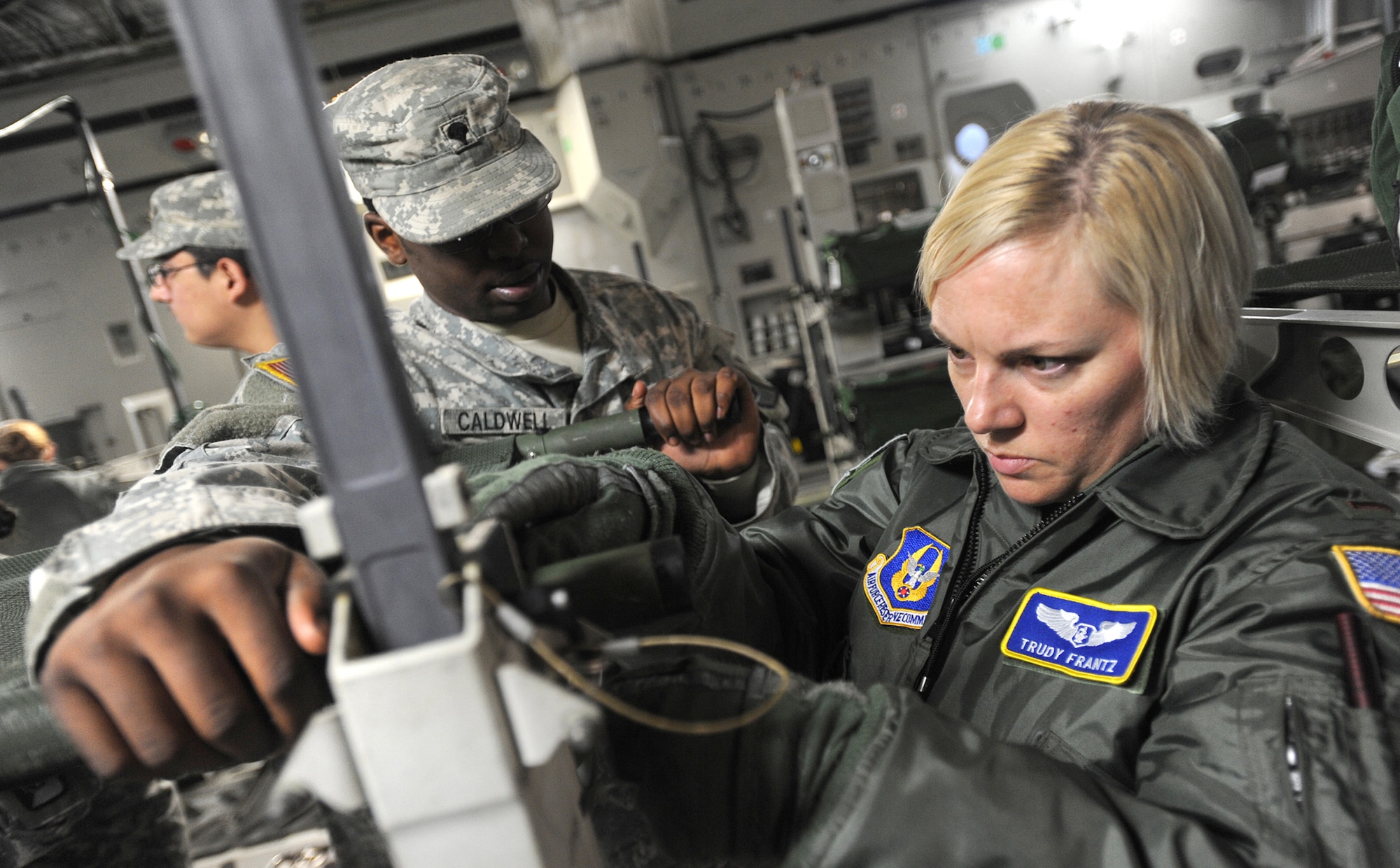 JOINT BASE LEWIS-MCCHORD, Wash.- Spc. Ryan Caldwell, left, 514th Med. Co., and 2nd Lt. Trudy Frantz, 446th Aeromedical Evacuation Squadron flight nurse, assemble a litter onboard a C-17 Globemaster III during a mass casualty exercise Dec. 7, 2010 here. Reservists with the 446th AES trained alongside Army medical personnel during the exercise. (Courtest photo/Ingrid Barrentine)
