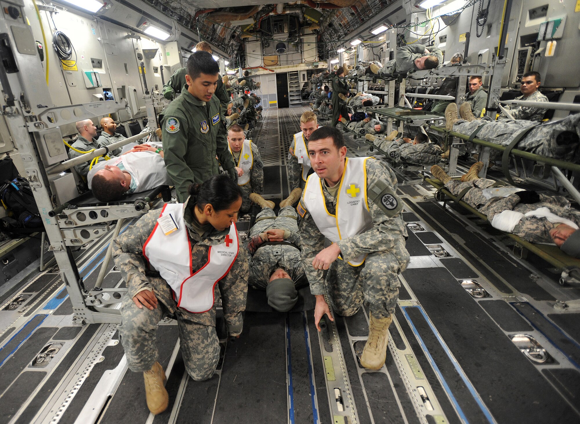 JOINT BASE LEWIS-MCCHORD, Wash.- Senior Airman ?Marcello Yamaguchi, left, 446th Aeromedical Evacuation Squadron medical technician, instructs Army medical personnel when to lift Spc. James Walden, a Soldier participating in a mass casualty exercise, Dec. 7, 2010 here. Reservists with the 446th AES trained alongside Army medical personnel during the exercise. (Courtesy photo/Ingrid Barrentine)