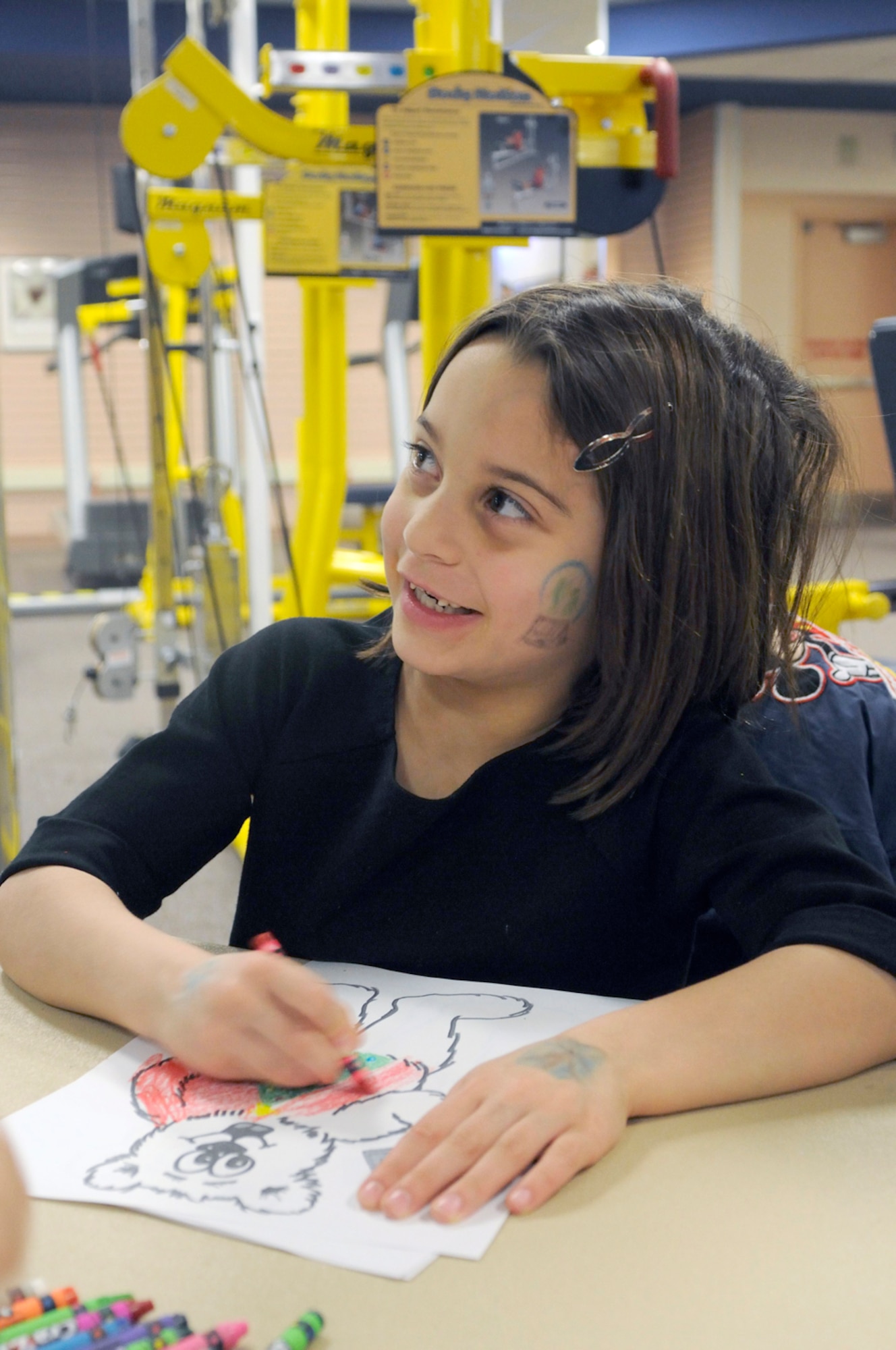 Anna Rosenberg, 6 years old, daughter of Coast Guard Lt. Cmdr.  Jim Rosenberg, Coast Guard Sector Anchorage, takes a break from her art work at the Breakfast with Santa hosted at the Arctic Oasis Community Center, Dec. 4. (U.S. Air Force photo/Steven White)