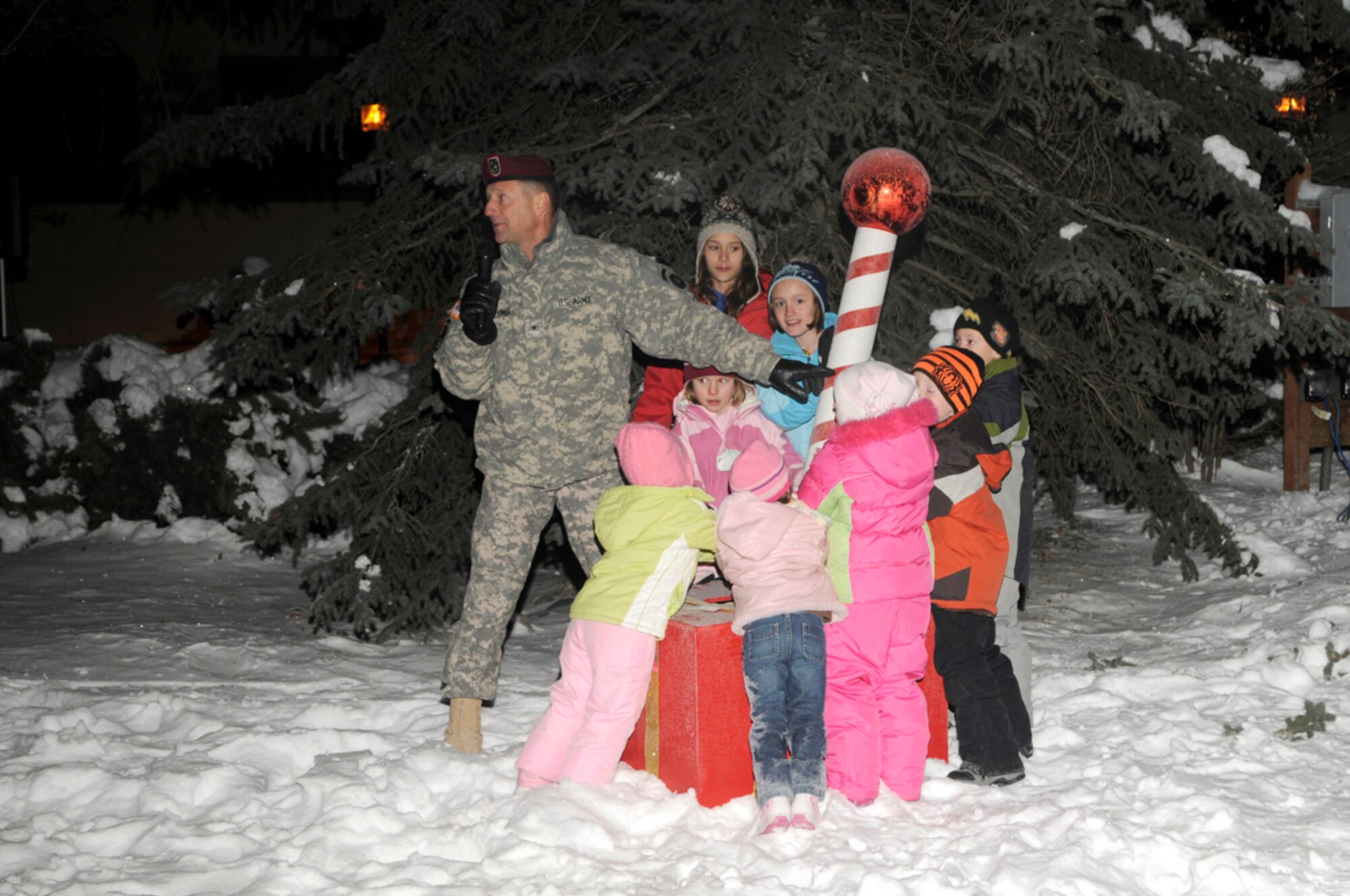 Army Brig. Gen Palumbo, U.S. Army Alaska commanding general, gets ready to turn the switch and light the tree with the help of children in front of USARAK headquarters, Dec. 2. (Photo by Steven White/JBER PAO)