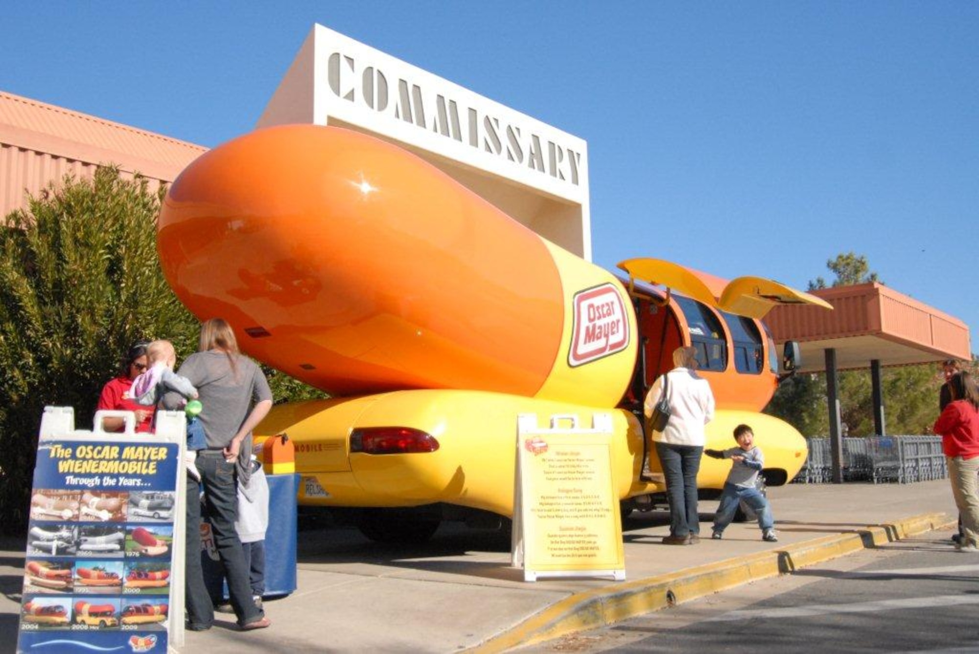 The Oscar Mayer Wienermobile rolled up to the Edwards commissary, Dec. 1 and made a stand – a hot dog stand – in front of the store. Wienermobile staff, known as Hotdoggers, spent the day “chillin’ and grillin’” as they handed out free hot dogs and stickers. Those who sang the “Oscar Mayer Wiener Song” earned a Wienerwhistle. Jaclyn Frumkin, a Wienermobile Hotdogger, said there are six Wienermobiles in the United States, each serving a different region. She said she and her staff are on the road for a year driving around the Southwest. The Wienermobile receives thousands of requests each year to appear at various events to promote Oscar Mayer wieners. An estimated 500 people from the Edwards community took pictures, ate food and looked inside the 27-foot hot dog on wheels. (Air Force photo by Kenji Thuloweit)