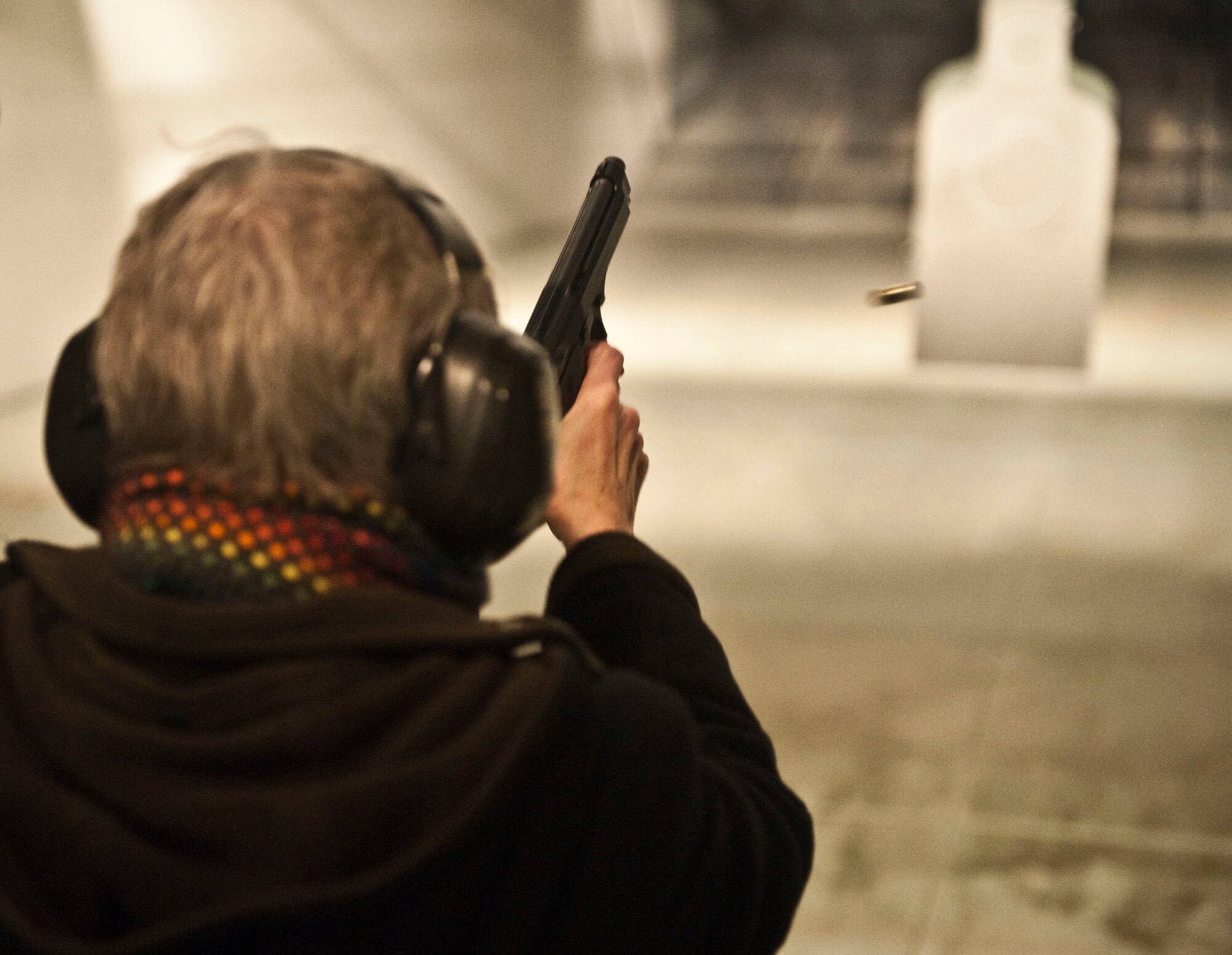 Anchorage School District Superintendent Carol Comeau fires a Beretta M9 9-millimeter pistol at the Joint Base Elmendorf-Richardson Combined Arms Training Facility. Comeau also witnessed a military working dog demonstration and climbed into the C-17 Globemaster III flight simulator. (U.S. Air Force photo/A1C Christopher Gross)