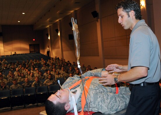 Chris Stocks, firefighter from Orlando, Fla. and "Street Smart" presenter, demonstrates an emergency medical procedure that would be utilized after an alcohol-related car accident, using Airman 1st Class Brian Lea, 22nd Maintenance Squadron aerospace ground equipment apprentice, Dec. 3, 2010, at McConnell Air Force Base, Kan. The one-hour presentation educated Airmen about the consequences of poor choices such as drunk driving and not wearing a seatbelt. (U.S. Air Force Photo/Airman 1st Class Andrea Salazar) 