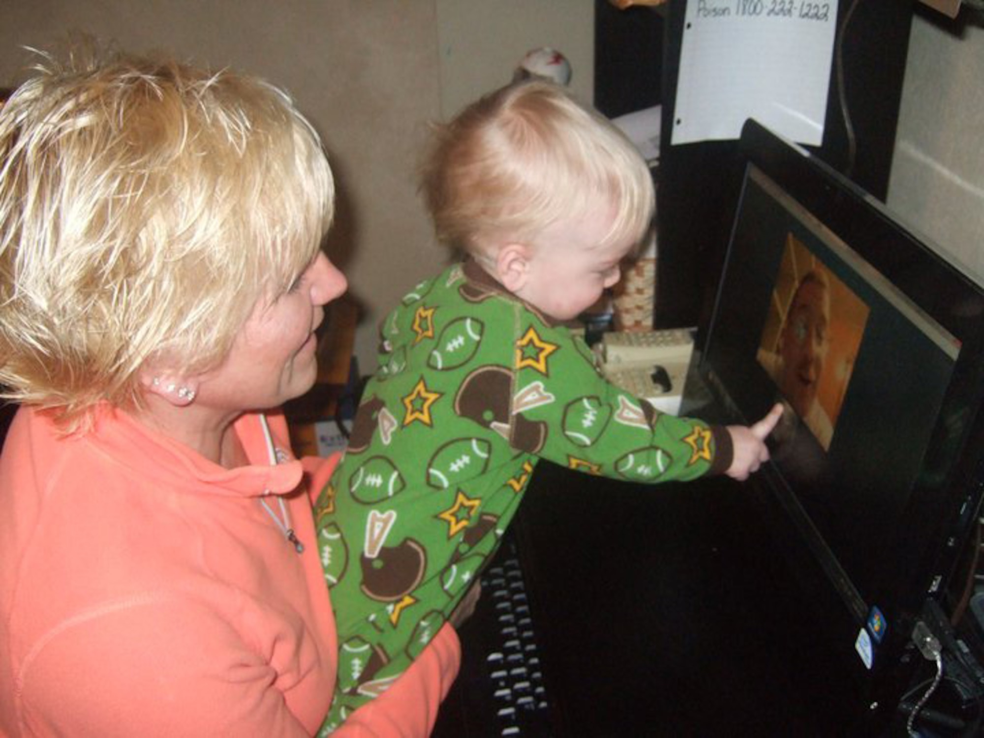 Lori Hill and her grandson Landon Hill, Sioux City, Iowa, talk with grandfather/Master Sgt. Marshall Hill of the 185th Air Refueling Wing over Skype. In February of 2010, the Air Force lifted the ban on social media sites such as Facebook and Skype, giving airmen another way to communicate with family and friends during deployments.    