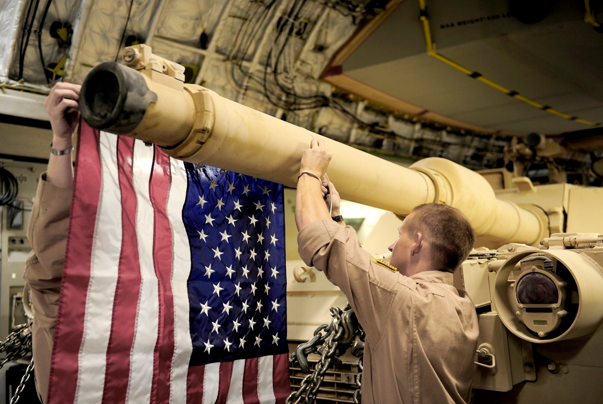 C-17 Globemaster III crewmembers tie an American flag onto a Marine Corps M1A1 Abrams tank at a base in Southwest Asia during an air transport Nov. 28, 2010, to Afghanistan in support of Operation Enduring Freedom on. The crew is assigned to the 816th Expeditionary Airlift Squadron. (U.S. Air Force Photo/Staff Sgt. Andy M. Kin)
