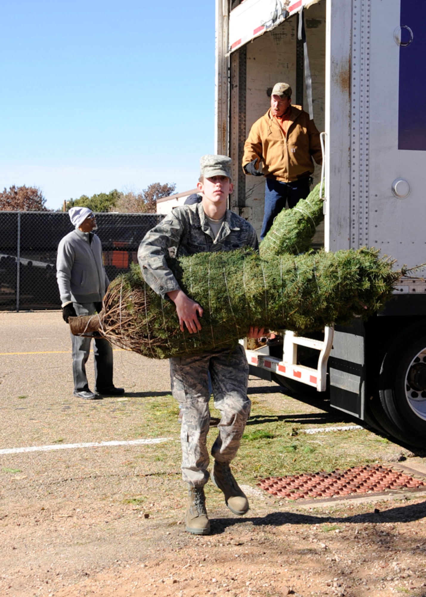 Airman 1st Class Zach Westerfield, 27th Special Operations Civil Engineer Squadron, offloads one of the more than 200 Christmas trees that were delivered to the Outdoor Recreation Center at Cannon Air Force Base, N.M., Dec. 8. The trees are part of the national Trees for Troops program and will be available for pick up free, on a first-come, first-served basis, Dec. 9. (U.S. Air Force photo by Greg Allen) 