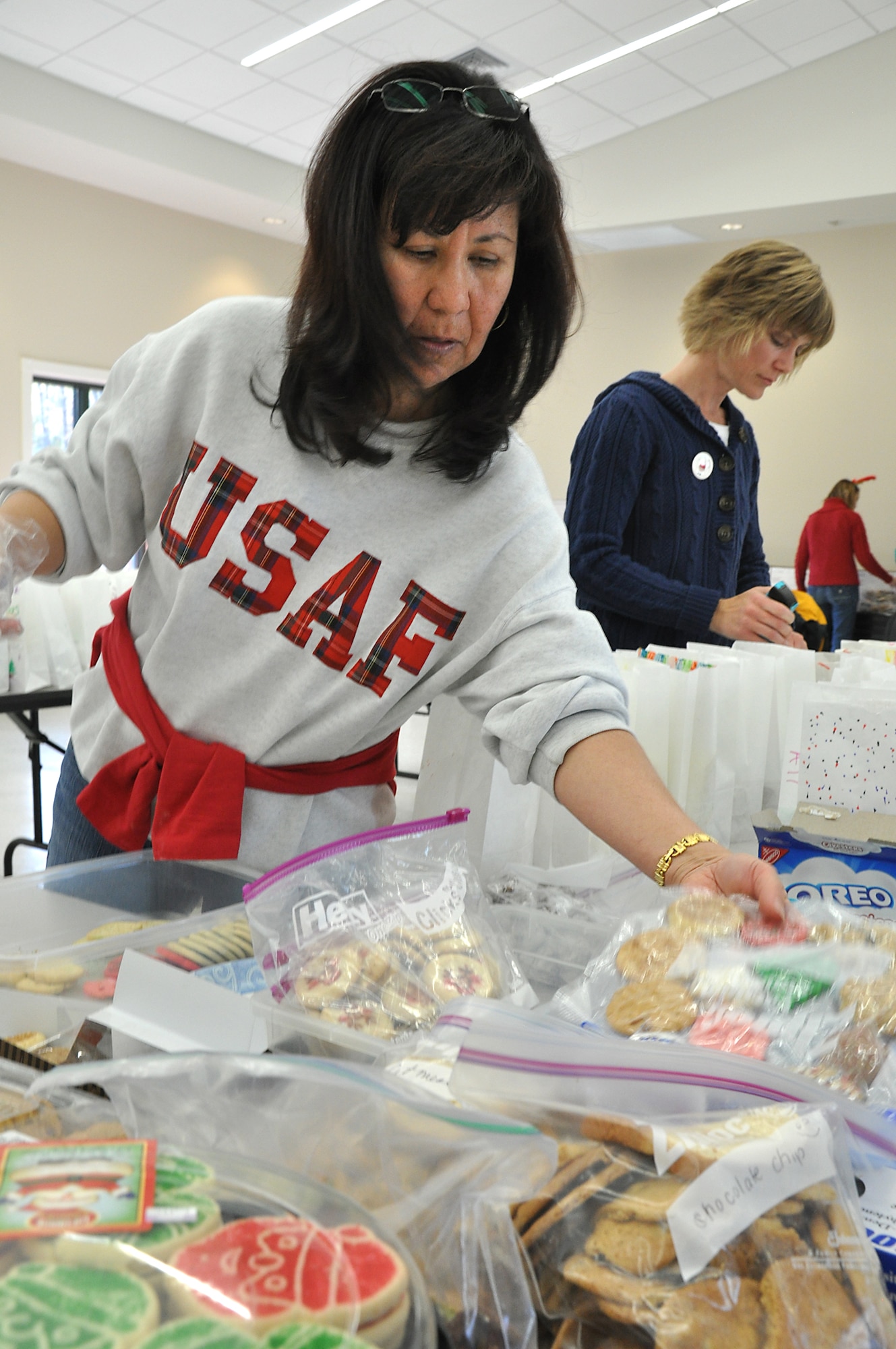 Nora Stephens, of the Team Charleston Spouses Club and wife of 315th Mission Support Group Commander Col. William Stephens prepares cookies to stuffed in bags in the base chapel annex during the club's 2nd annual Cookie Drop.
