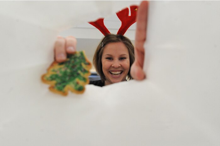 Rose Sharp drops a holiday cookie into a bag during the annual the Team Charleston Spouses' Club Cookie Drop at Joint Base Charleston-Air Base, S.C., Dec. 8, 2010. This year, the TCSC put together more than 500 bags and boxes of holiday cookies for service members living in the base dormitories, eating at the dining facility and who are deployed. Ms. Sharp is the president of the TCSC. (U.S. Air Force photo/James M. Bowman)