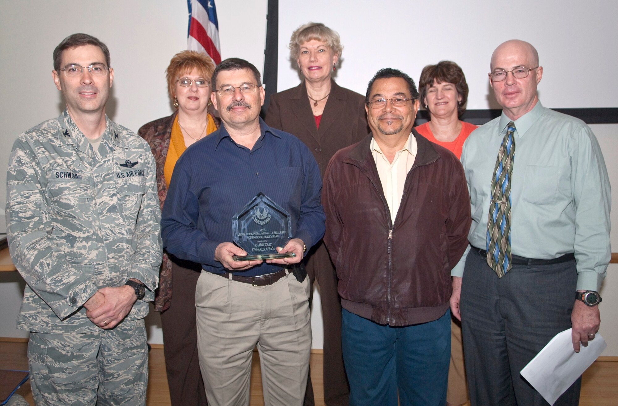 Staff members from 95th Civil Engineering Division pose for a picture with Col. Gregory E. Schwab after receiving the Brig. Gen. Michael A. McAuliffe Housing Excellence Award during the ABW weekly staff meeting, Dec. 1. (Air Force photo by Michael Yncera)