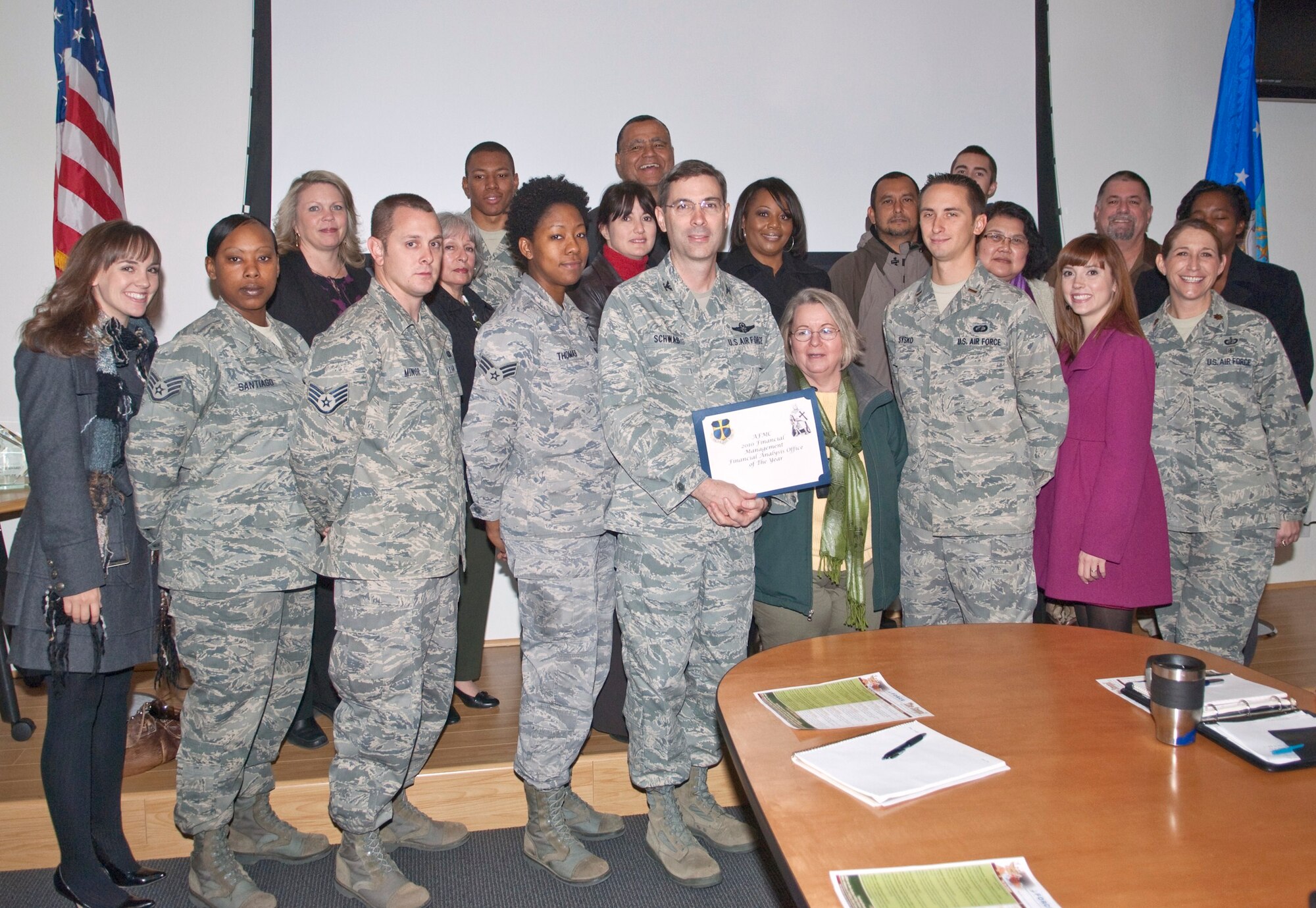 Col. Gregory E. Schwab, 95th Air Base Wing commander, presents the 2010 Air Force Materiel Command Financial Analysis Office of the Year Award to the 95th ABW Financial Analysis Office, during the wing’s weekly staff meeting, Dec. 1. (Air Force photo by Michael Yncera)