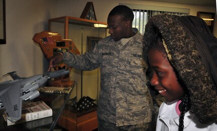 Khaliya Banks gets a close look of a model C-17 at the Airman Leadership School with her "buddy," Senior Airman Keith Barnett, during a base tour Dec. 2, 2010, on Joint Base Charleston-Air Base, S.C. Khaliya and fellow students from Memminger Elementary School's third grade toured the base as part of an annual program. Students were paired up with ALS students, who answer their questions and feed their curiosity with knowledge about the Air Force mission. (U.S. Air Force photo/Staff Sgt. Daniel Bowles)